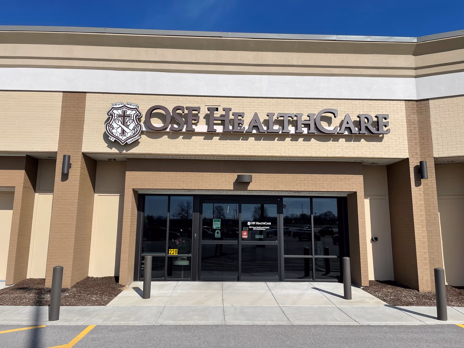 Front exterior of an OSF HealthCare building with glass entrance doors.