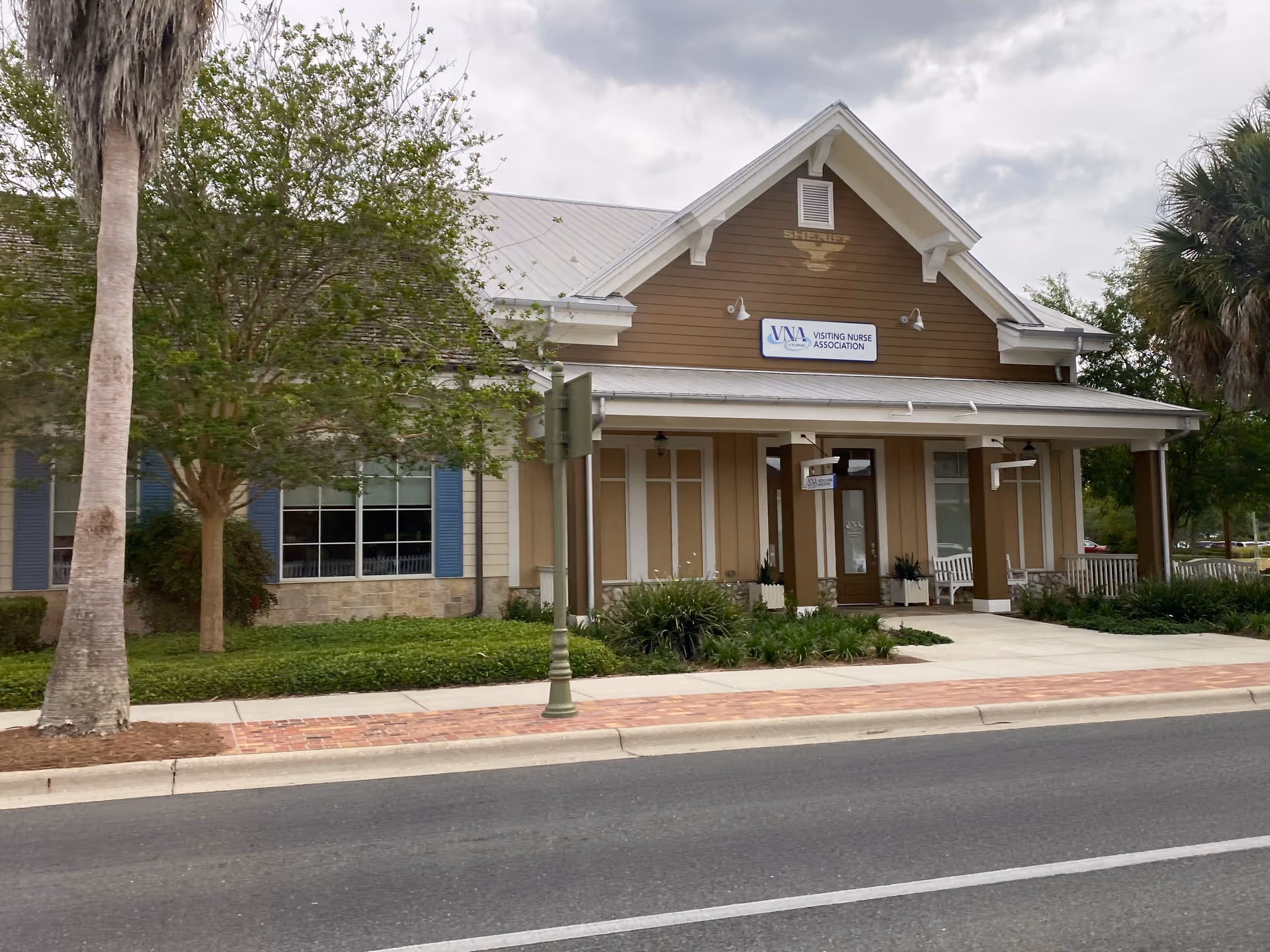 Front exterior of Visiting Nurse Association of Florida building with trees and sidewalk.