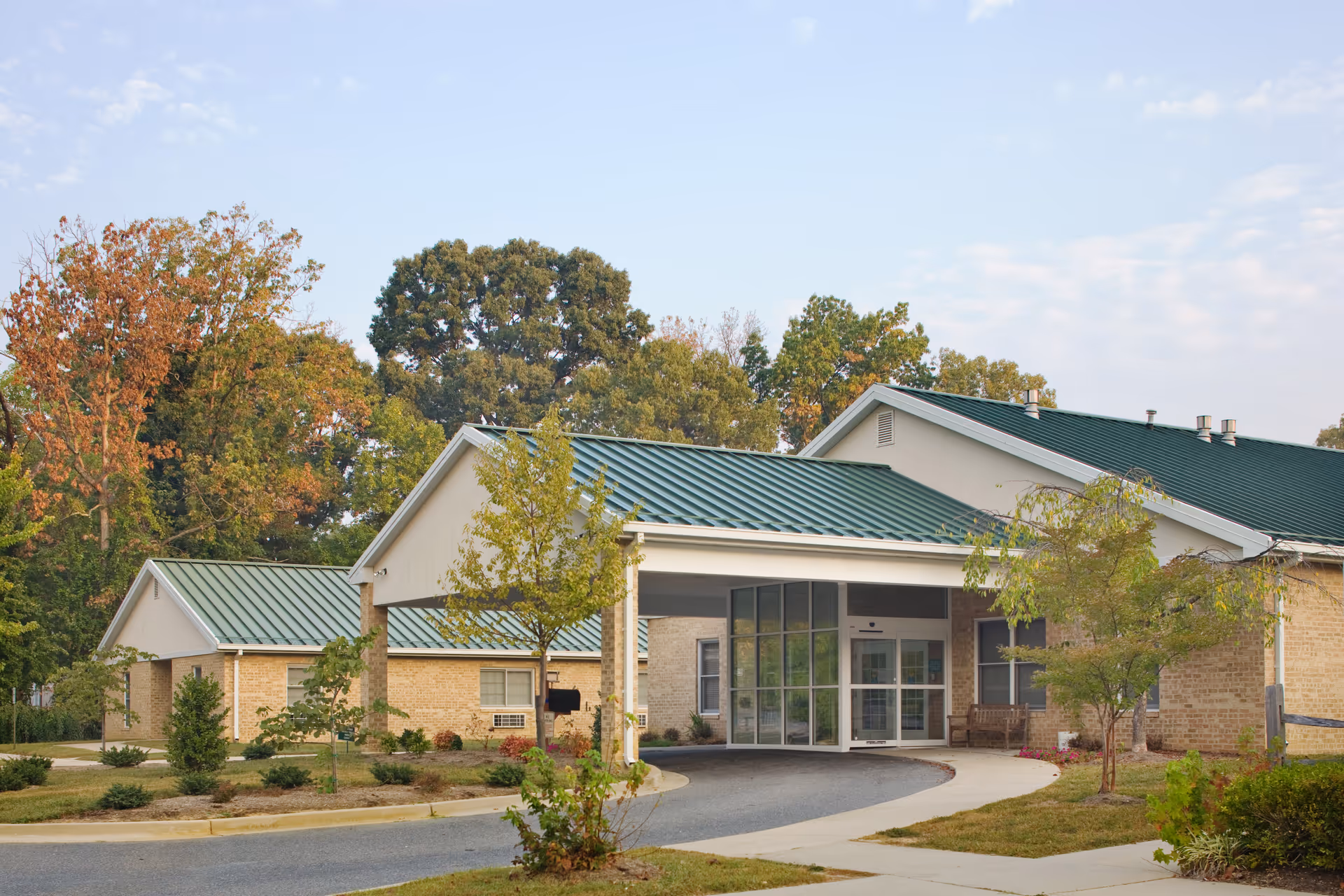 Exterior view of Waldorf Center with green metal roofs and glass entrance doors.