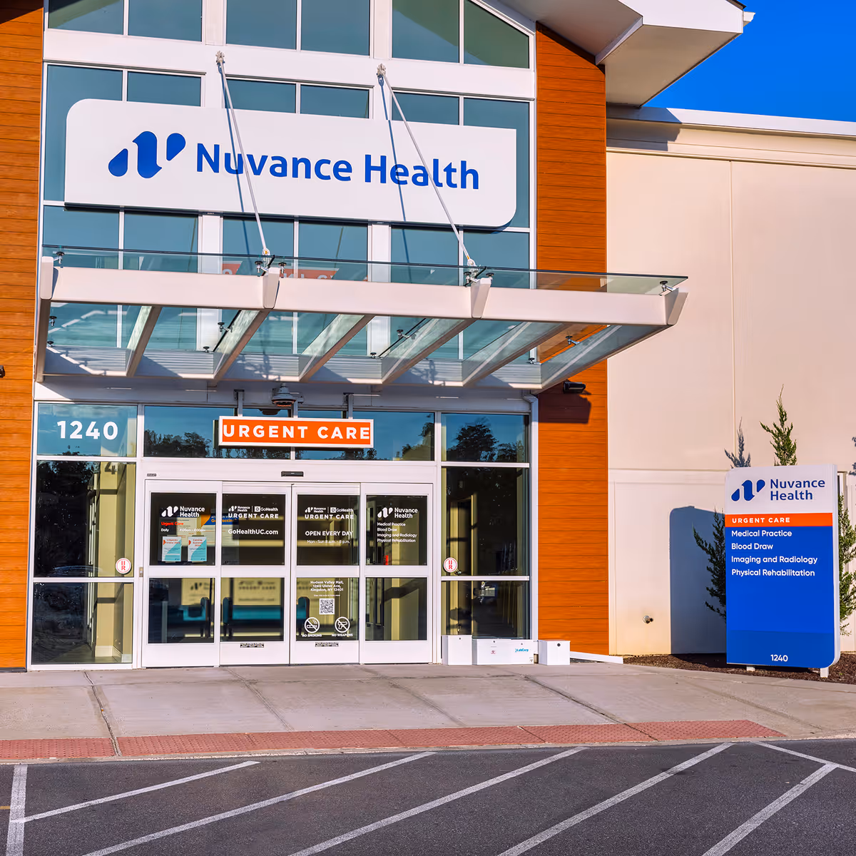 Modern medical clinic exterior with glass doors, signage, and Urgent Care banner.