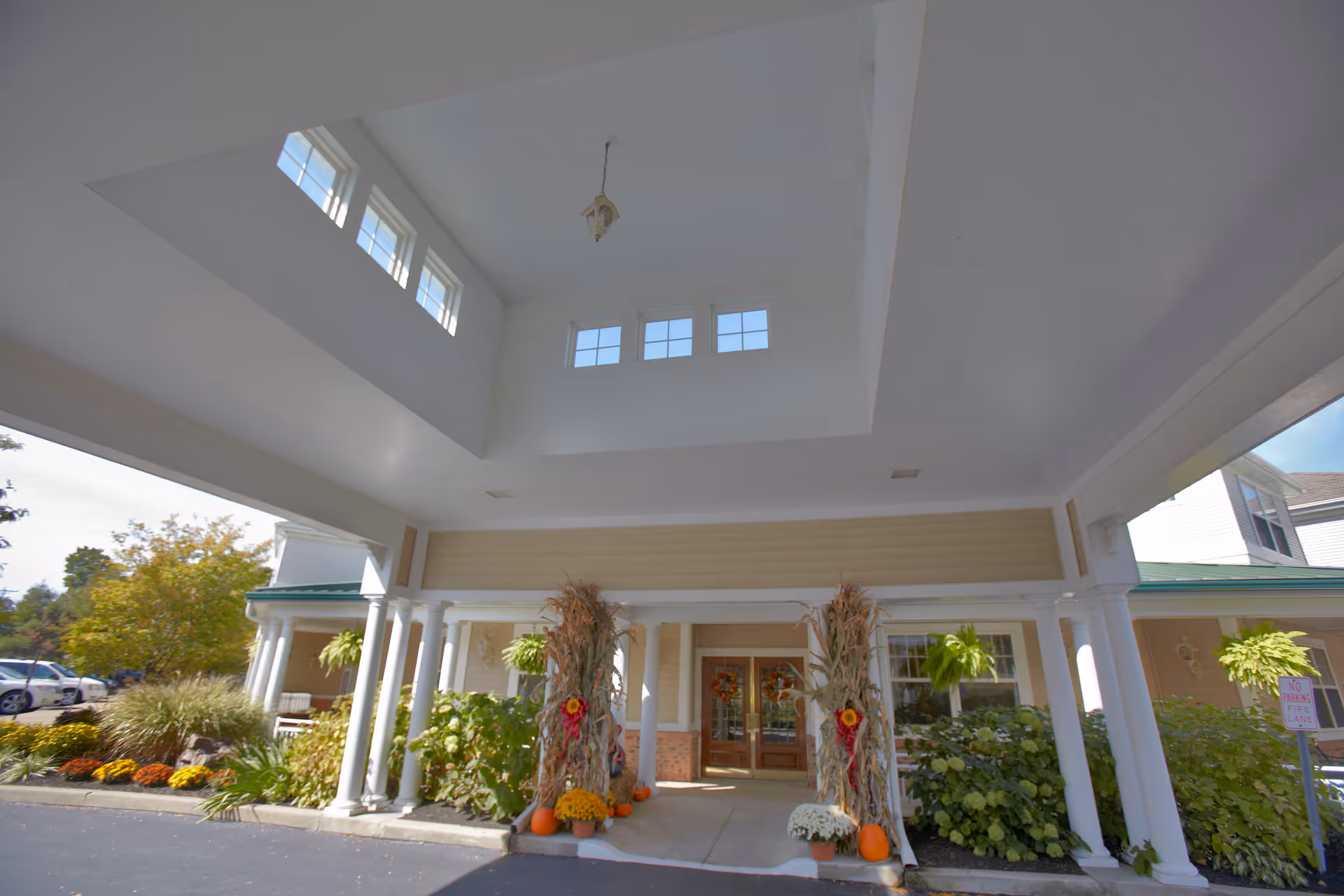Front entrance of Westlake Woods Assisted Living with pillars, a covered portico, and autumn decorations.