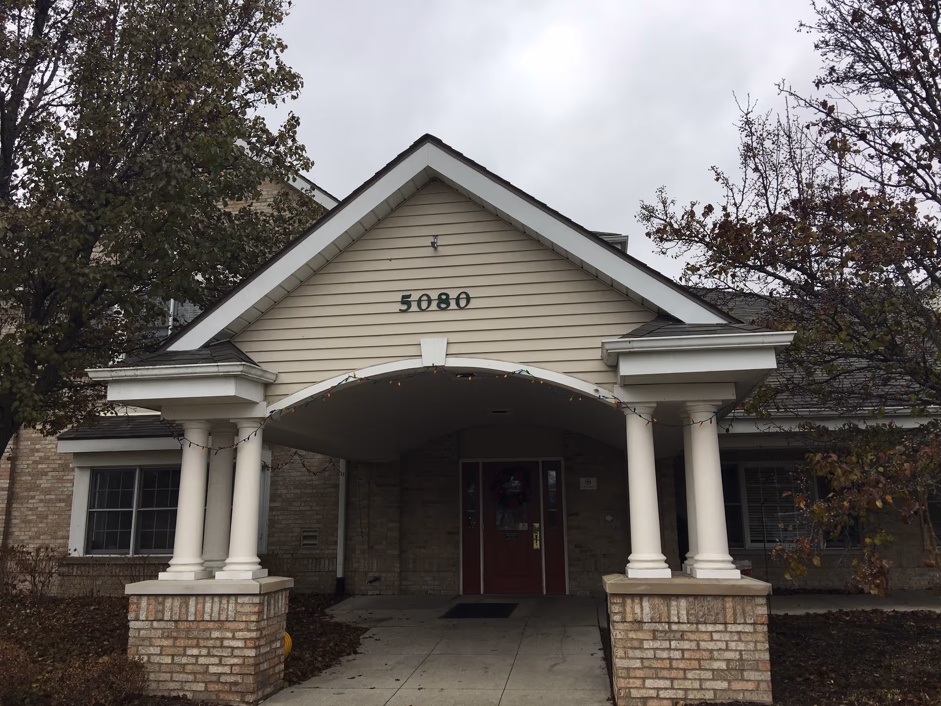 Front entrance of Brookdale Grand Blanc with arched portico and brick columns.