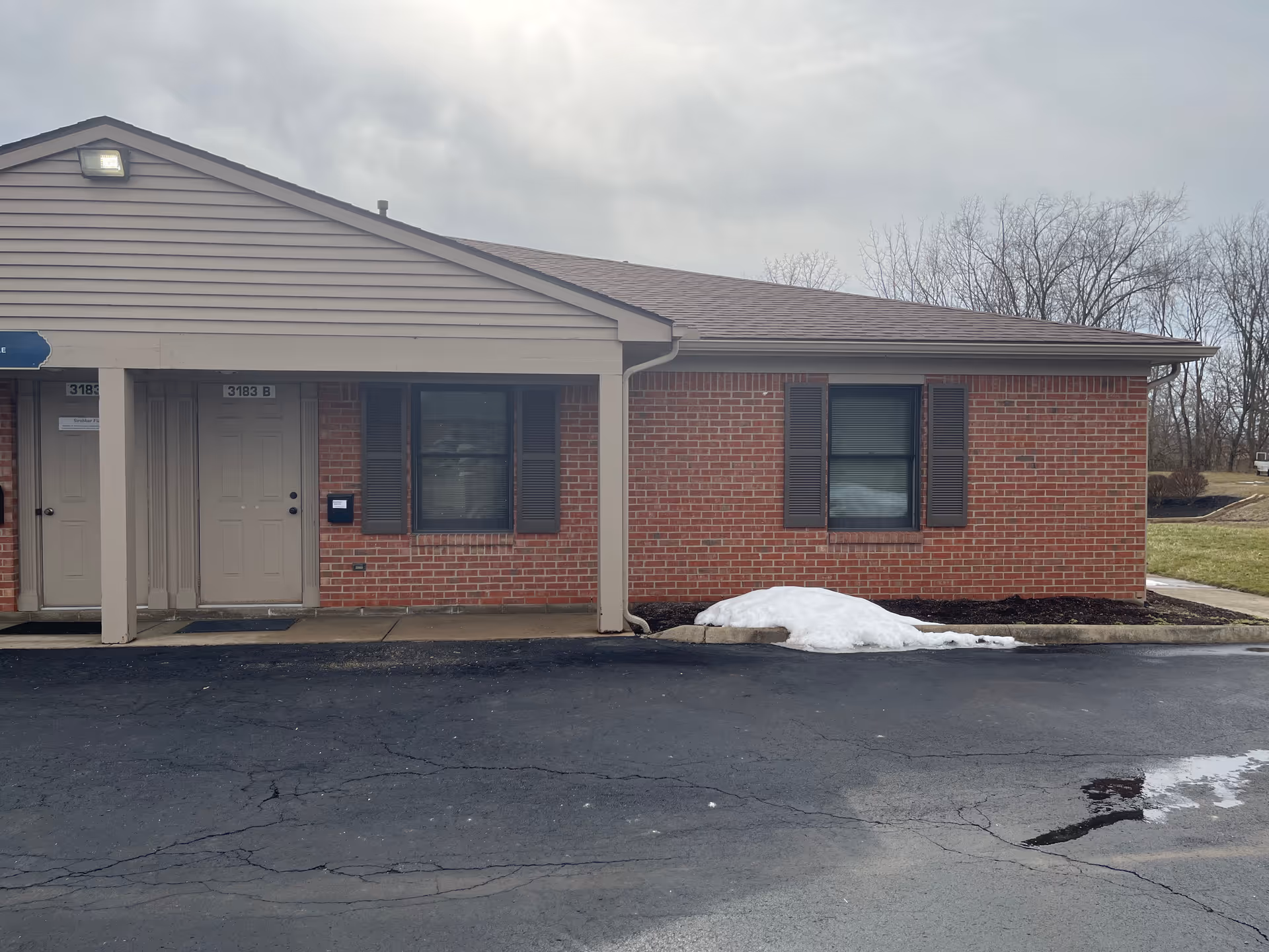 Exterior view of a brick senior living facility with a covered entrance.