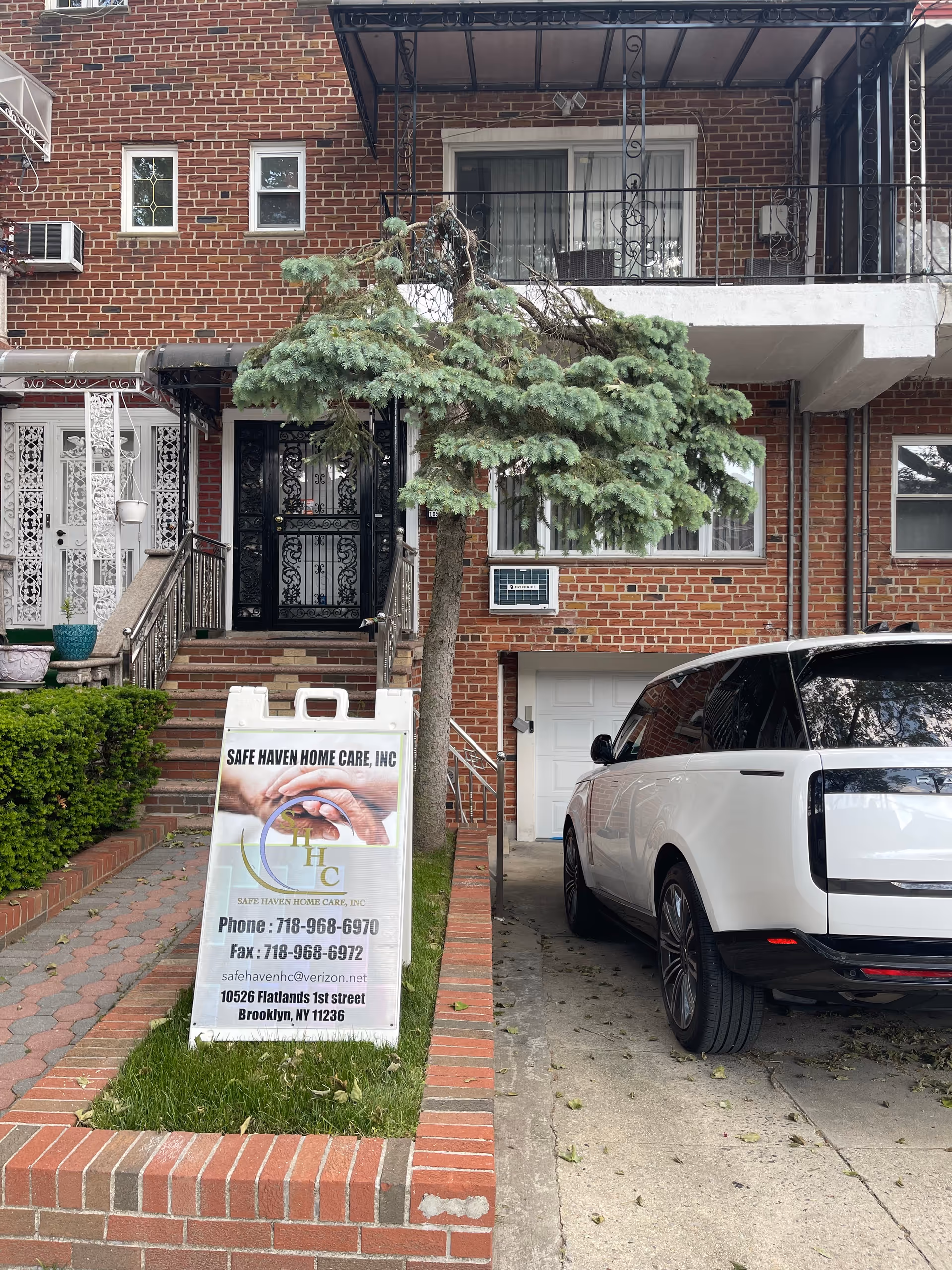 Brick building storefront with a sign for Safe Haven Home Care and a parked white SUV.