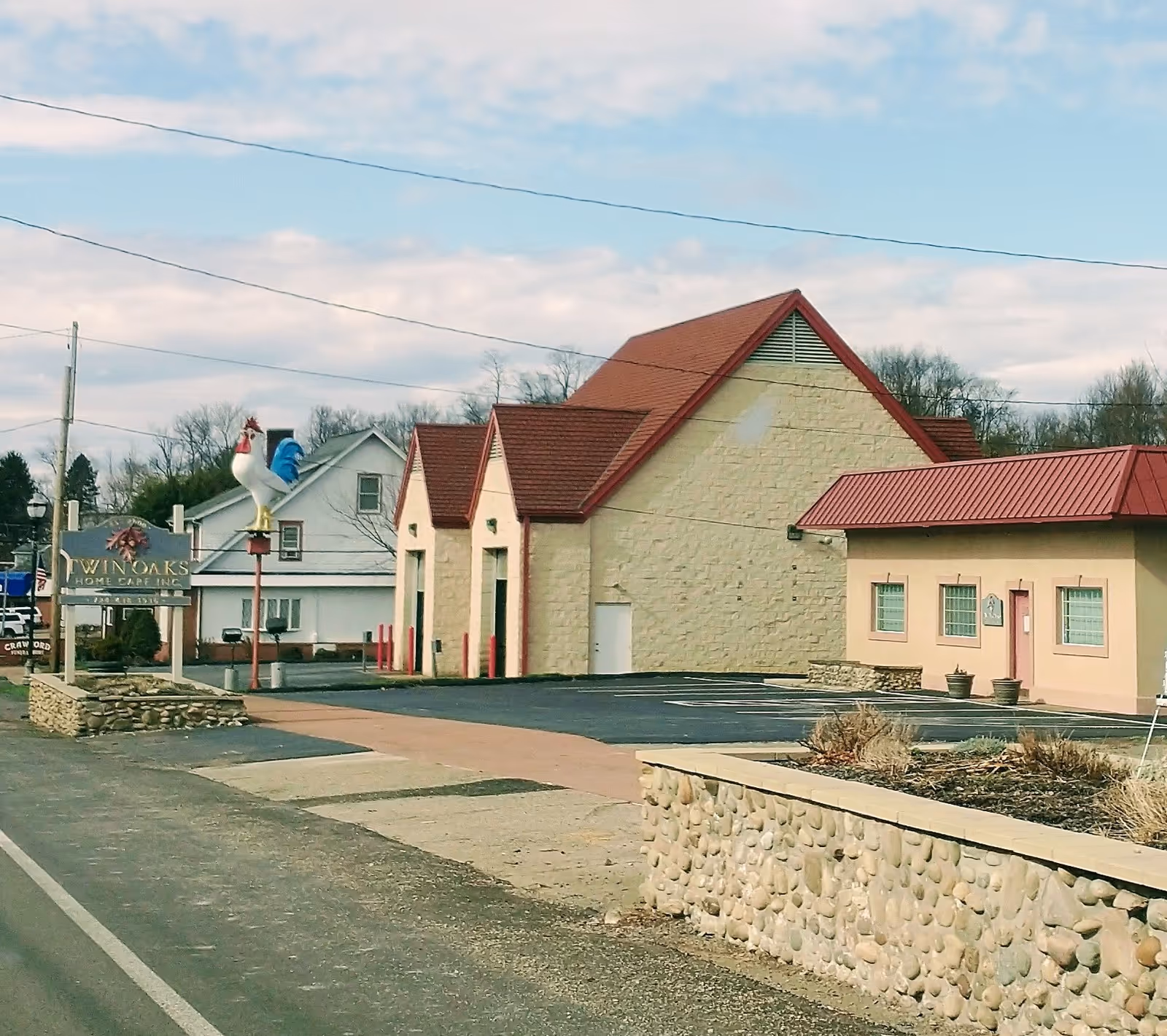 Exterior view of Twin Oaks Home Care facility with stone walls and red roofs.