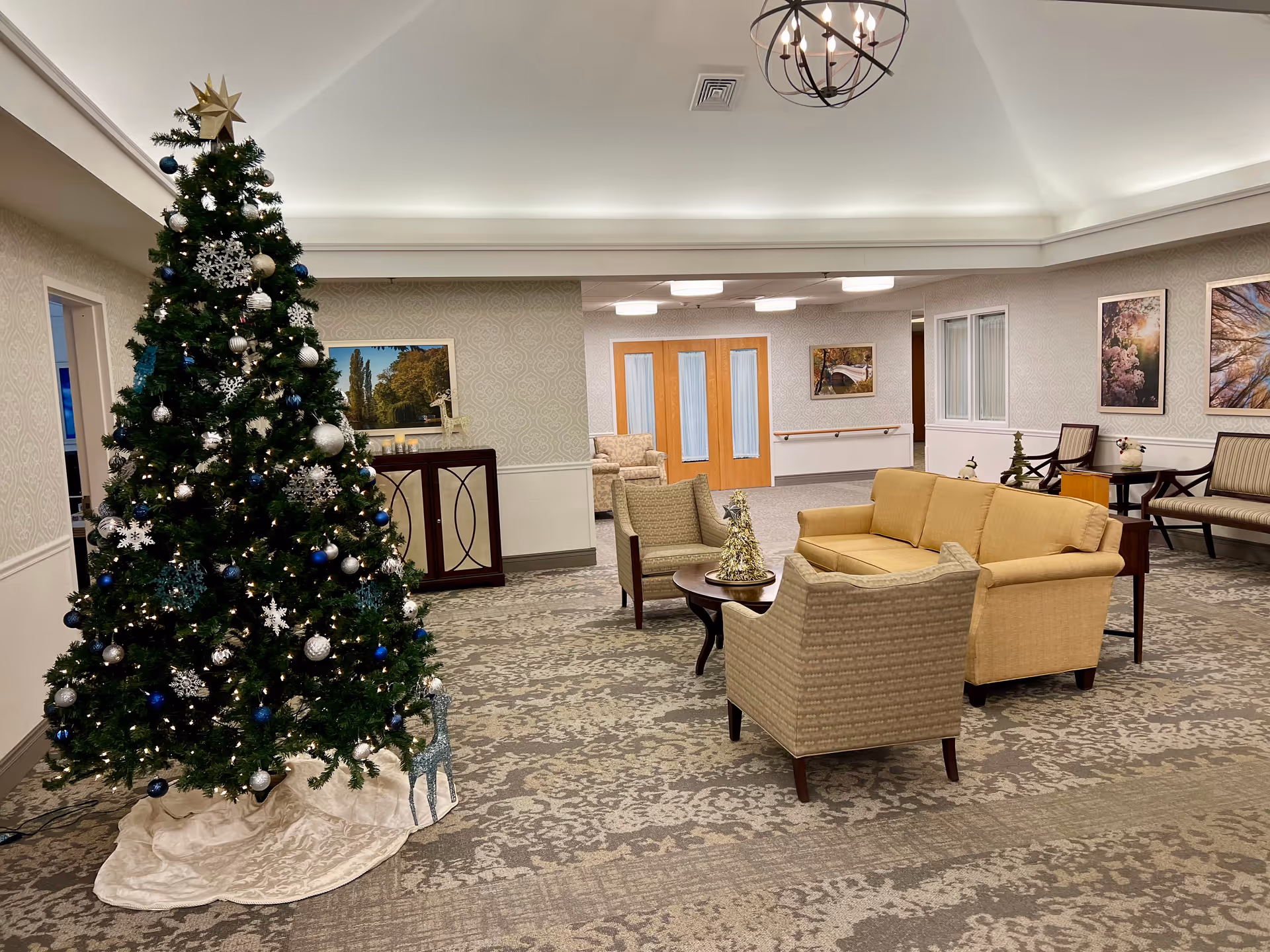 Spacious senior living lobby with a large Christmas tree and beige seating.