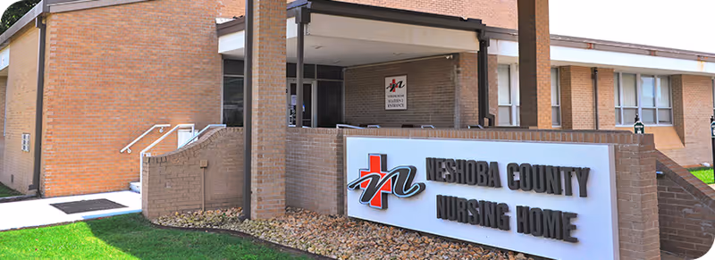 Exterior view of Neshoba County Nursing Home with brick facade and entrance.