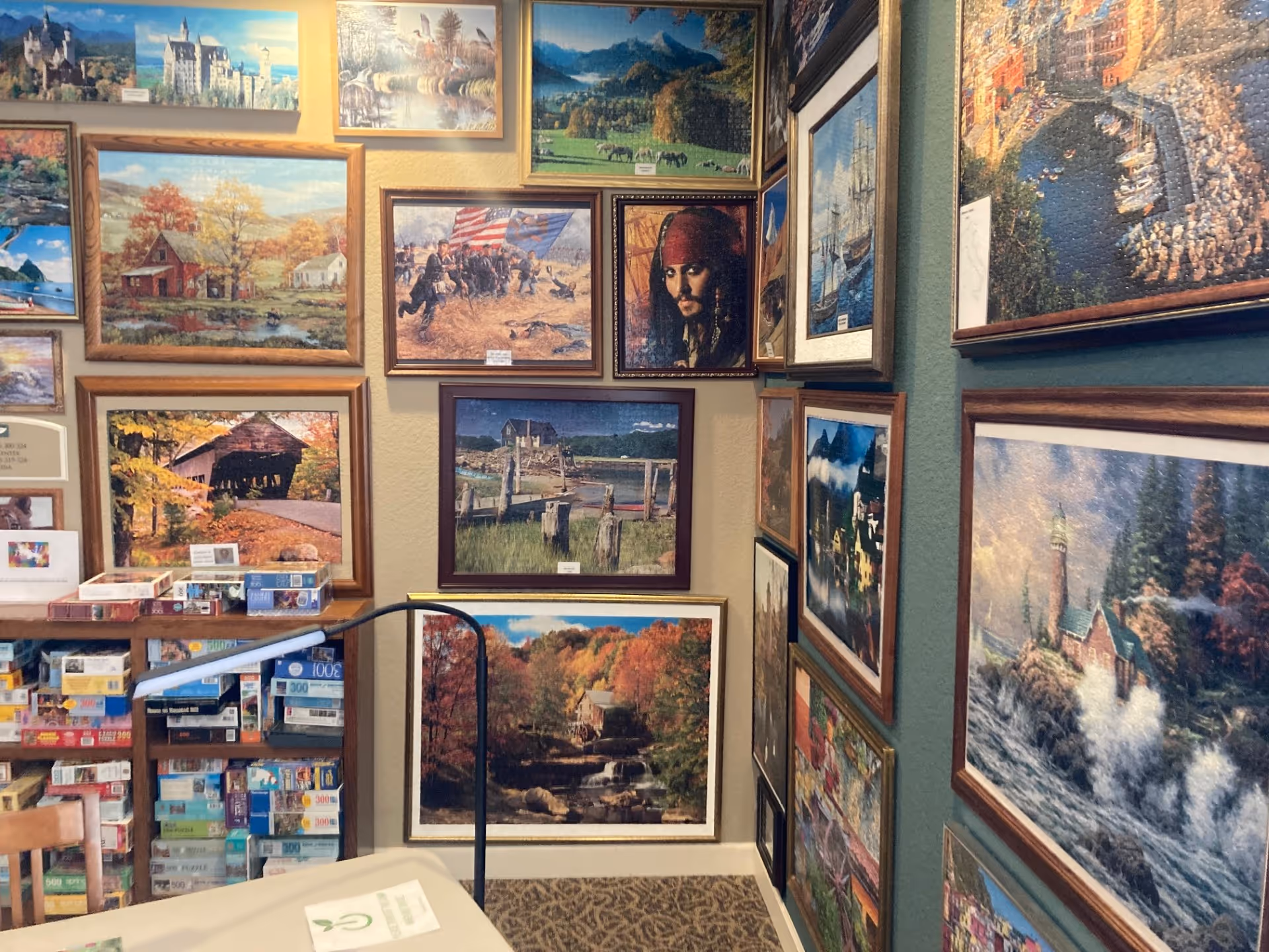 Interior hallway in a senior facility, walls filled with numerous framed landscape paintings.