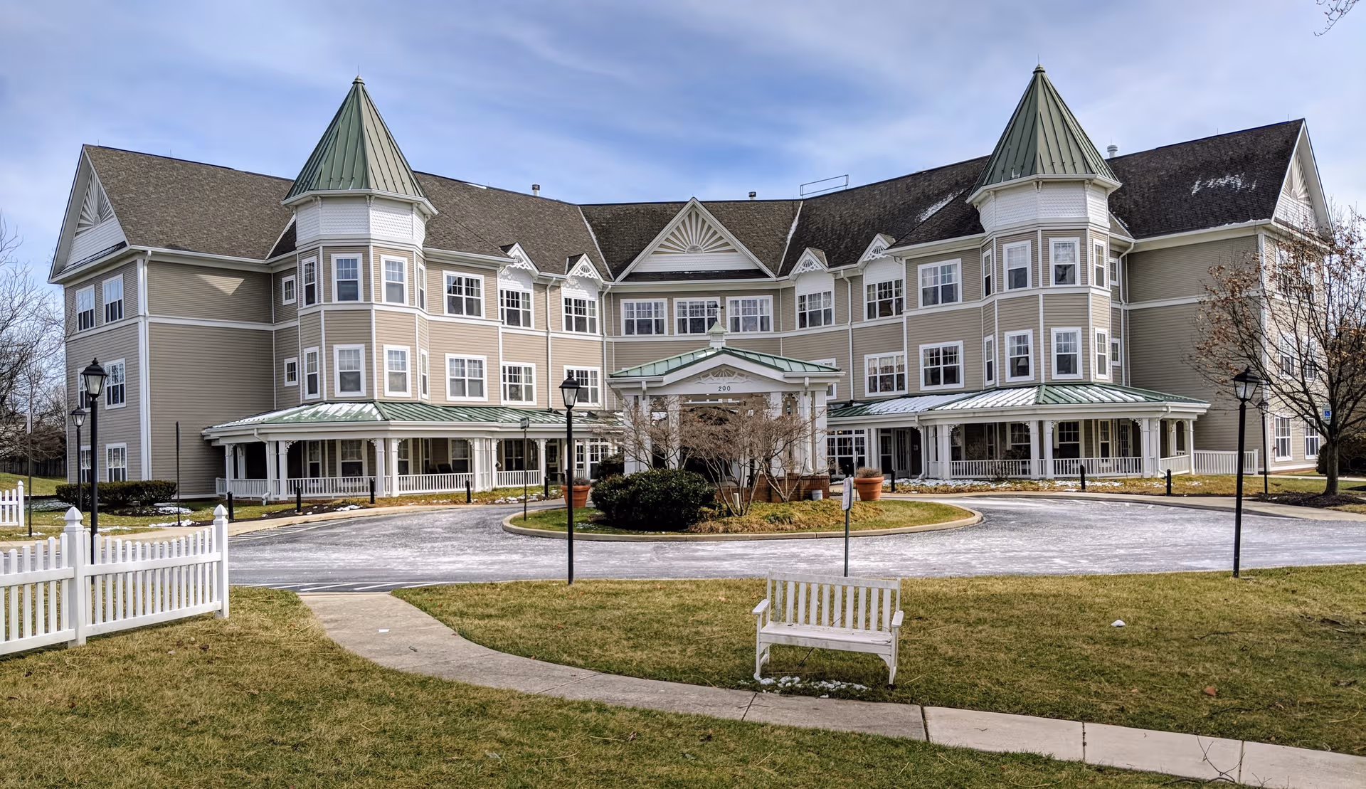 Large multi-wing senior living building with green roofs and circular driveway at front.