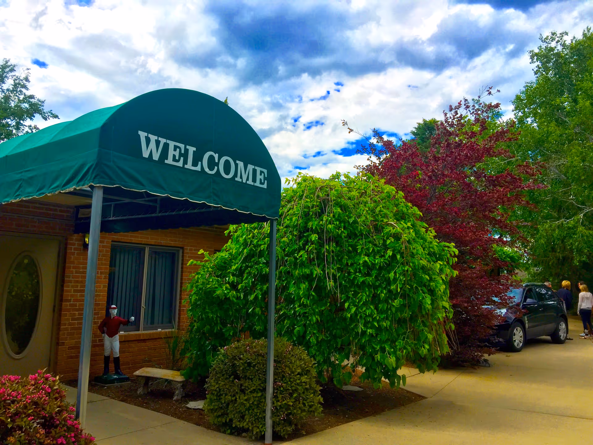 Green canopy with 'WELCOME' over the entrance of Greenleaf Care Home.