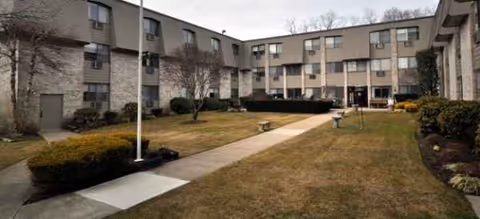 Exterior view of Anchor Bay at Greenwich showing a courtyard and walkway to the entrance.