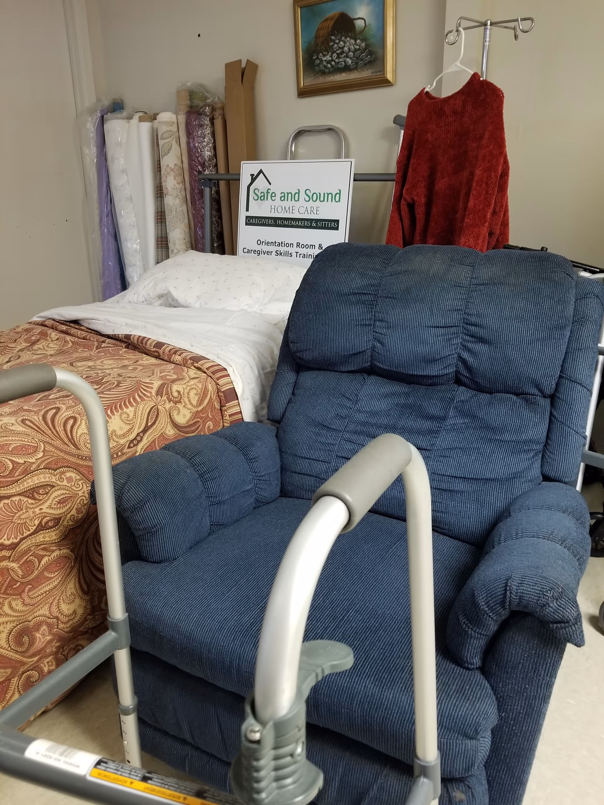 Caregiving equipment and a blue recliner chair in a furnished care room.