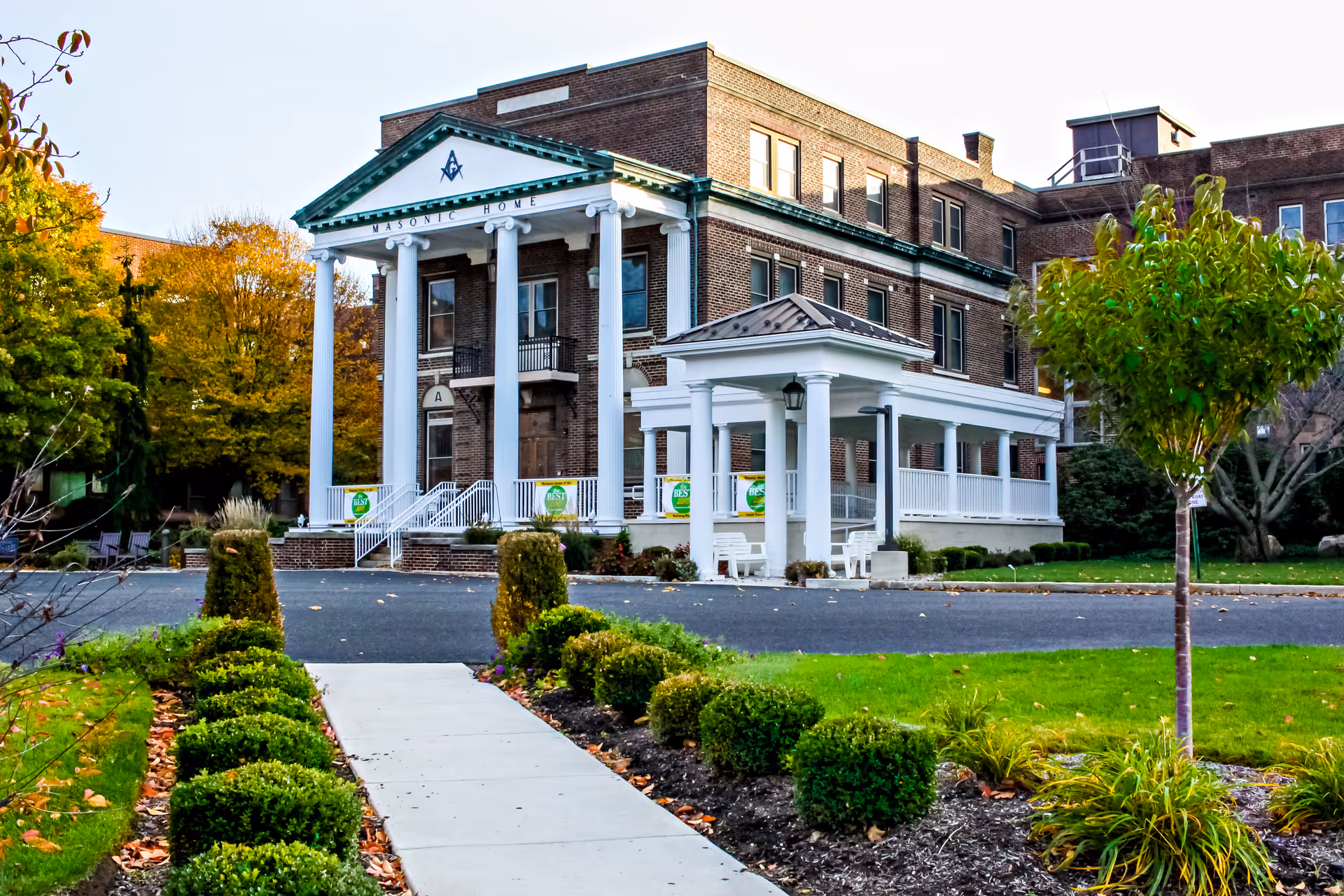 Front of Masonic Village at Burlington: brick building with tall white columns and a covered entrance.