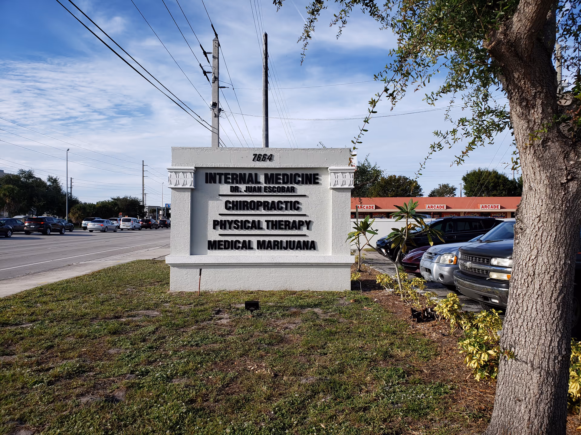 Front exterior sign advertising medical and chiropractic services along a busy street.