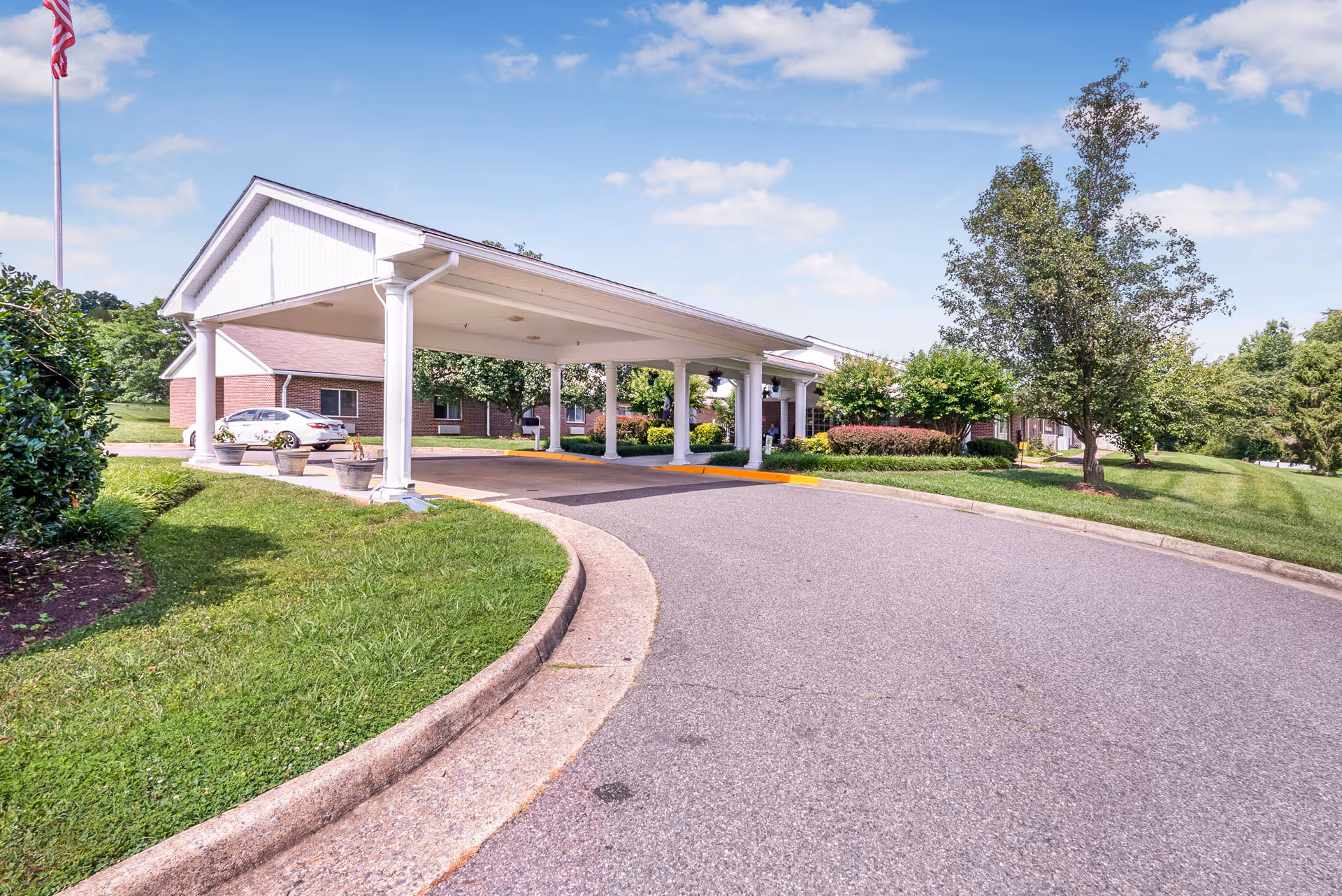 Front entrance of Meadows Nursing Center with a covered driveway and green landscaping.