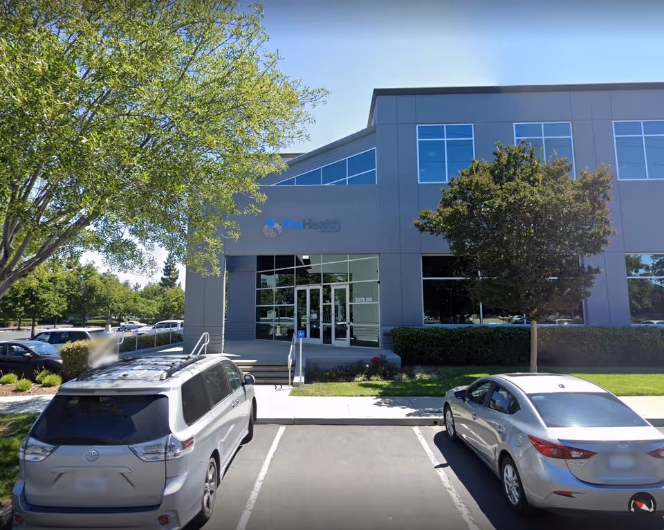 Exterior view of ProHealth Home Care building with entrance, trees, and parked cars.