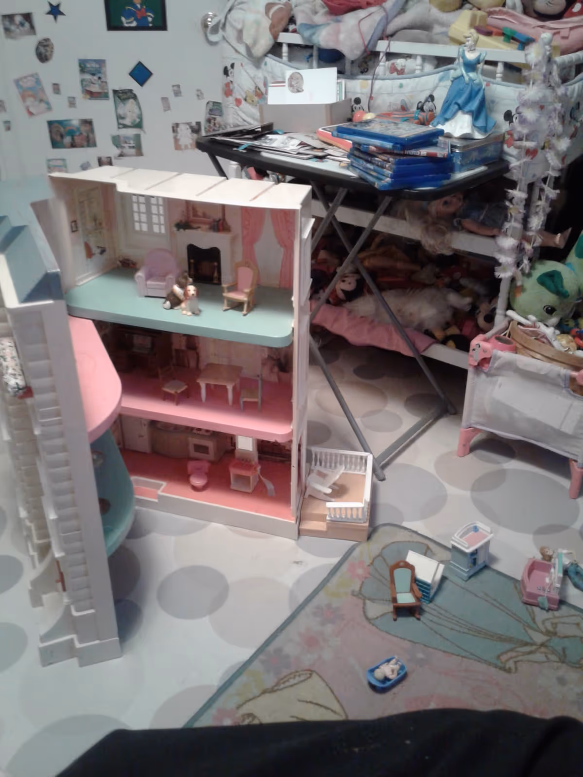 Colorful dollhouse and toy clutter fill a child's playroom.