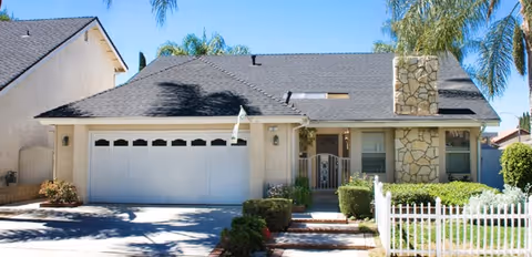 Single-story nursing home exterior with a two-car garage and landscaped front yard.