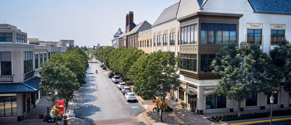 Elevated street view of a tree-lined Main Street with shops and cars.