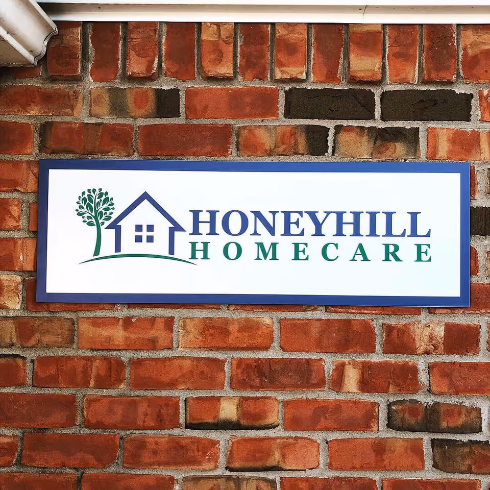 HoneyHill HomeCare sign mounted on a red brick exterior wall.