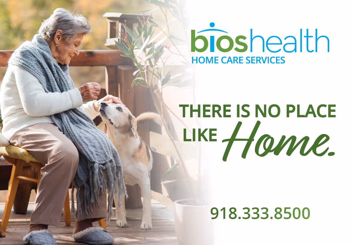 Elderly woman sits outdoors on a wooden deck with a dog.
