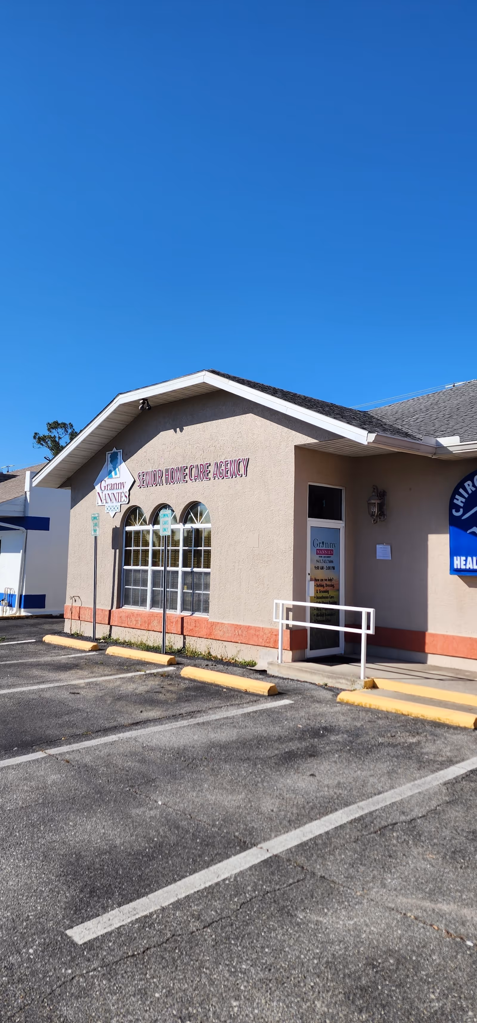 Exterior view of a Granny NANNIES senior home care building with parking.