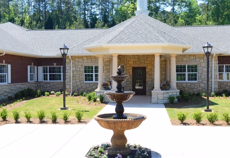 Front view of Reserve at Towne Lake with stone exterior, columns, and fountain.
