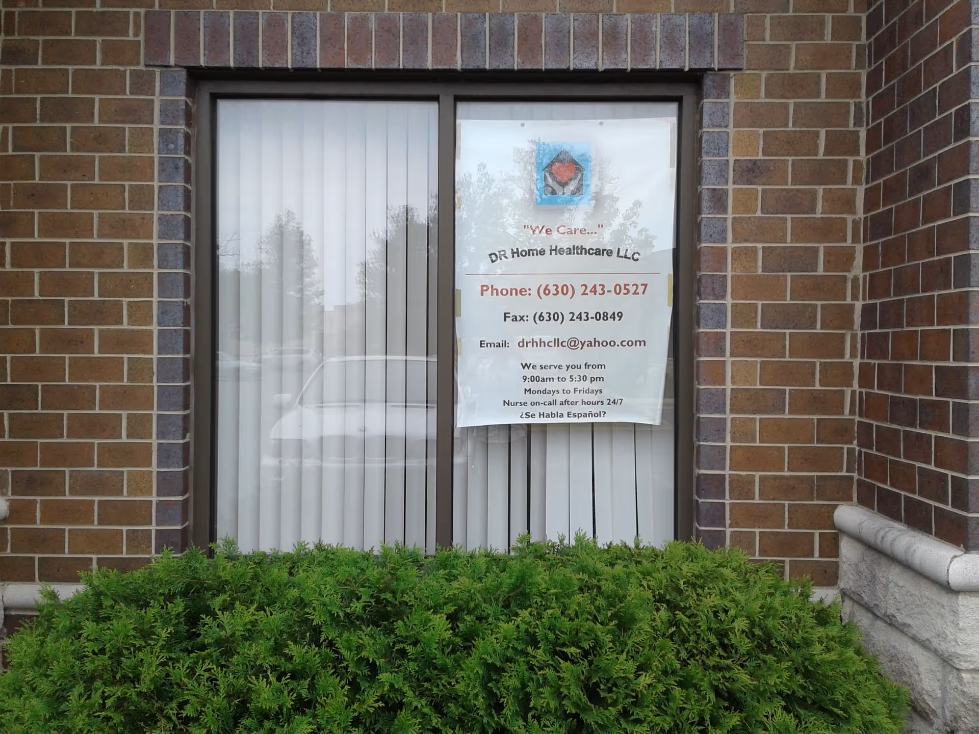 Brick building exterior with a window and a DR Home Healthcare LLC banner.
