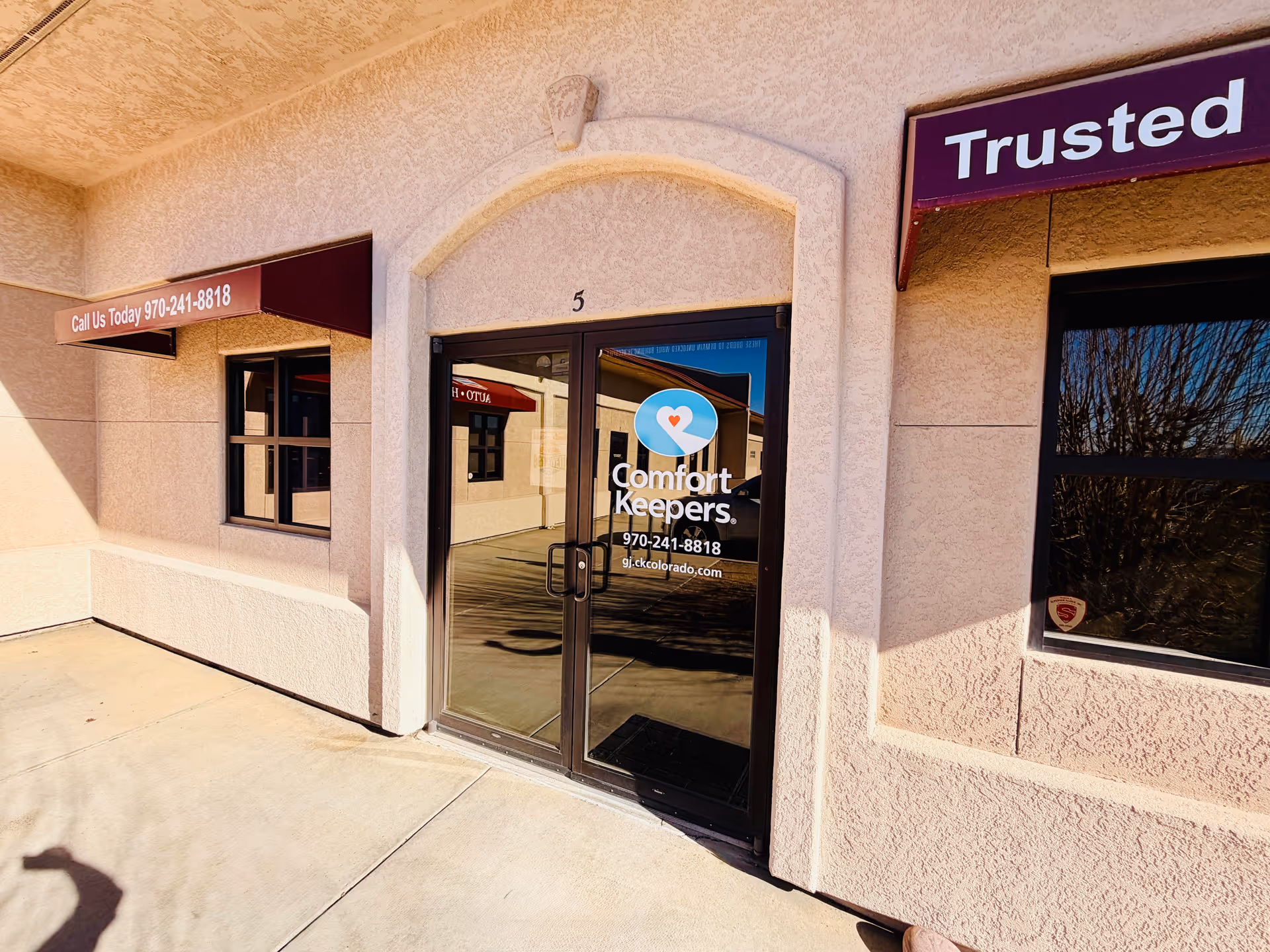 Exterior view of Comfort Keepers Home Care entrance with glass doors.