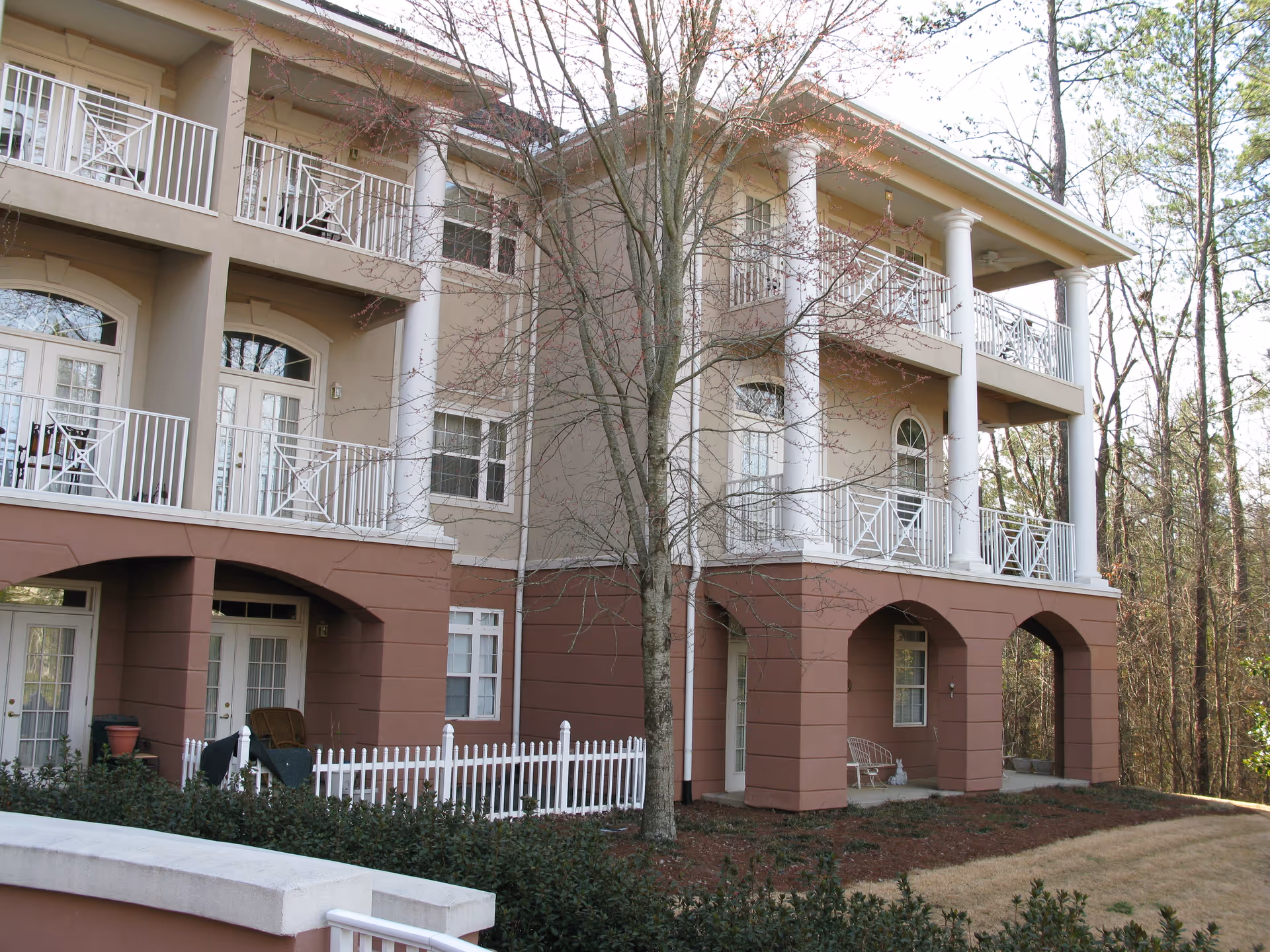 Exterior view of Ivy Hall senior living building with balconies and arched entryways.
