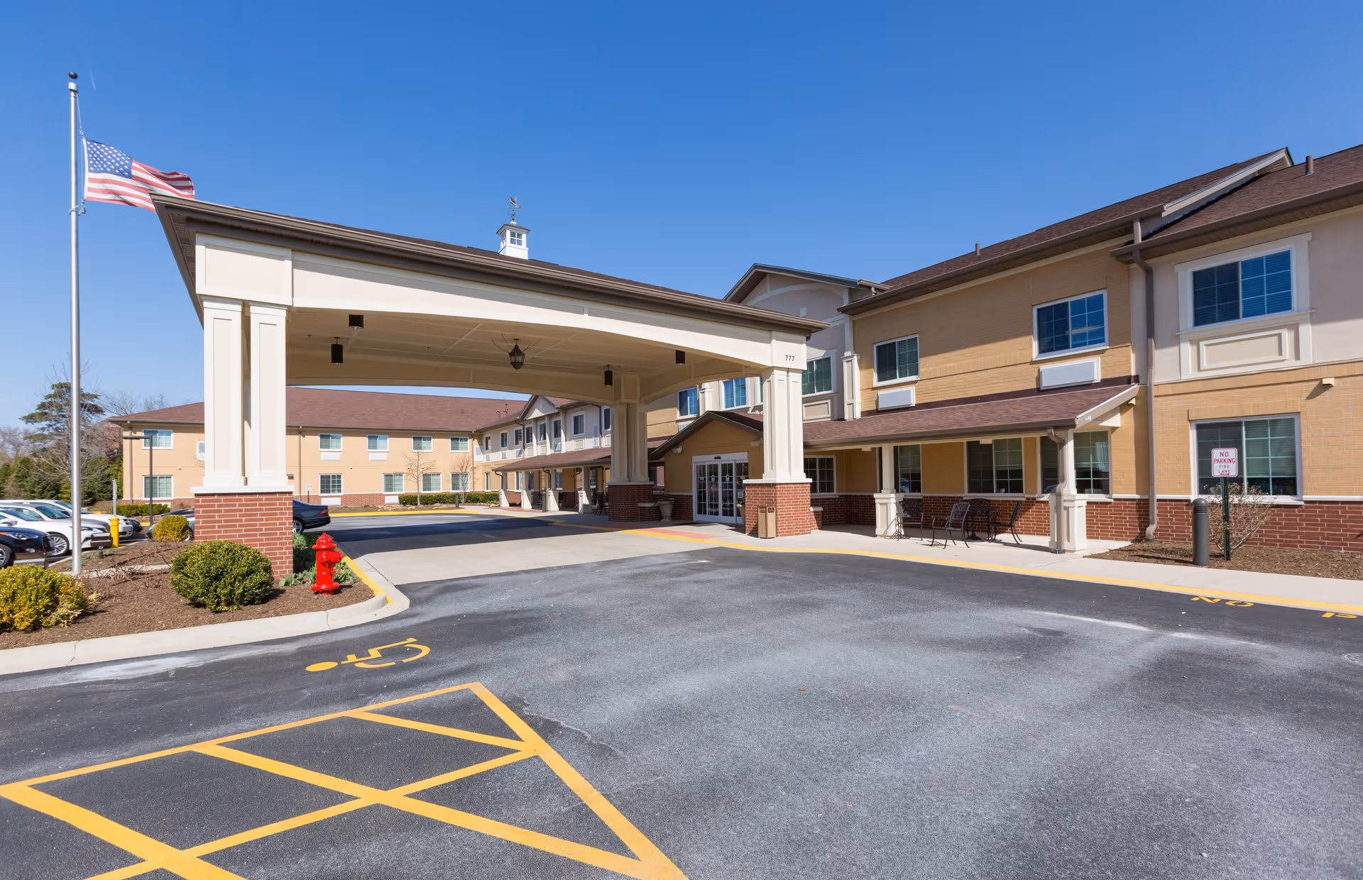 Cedar Lake Assisted Living and Memory Care entrance with a covered drive and flag.