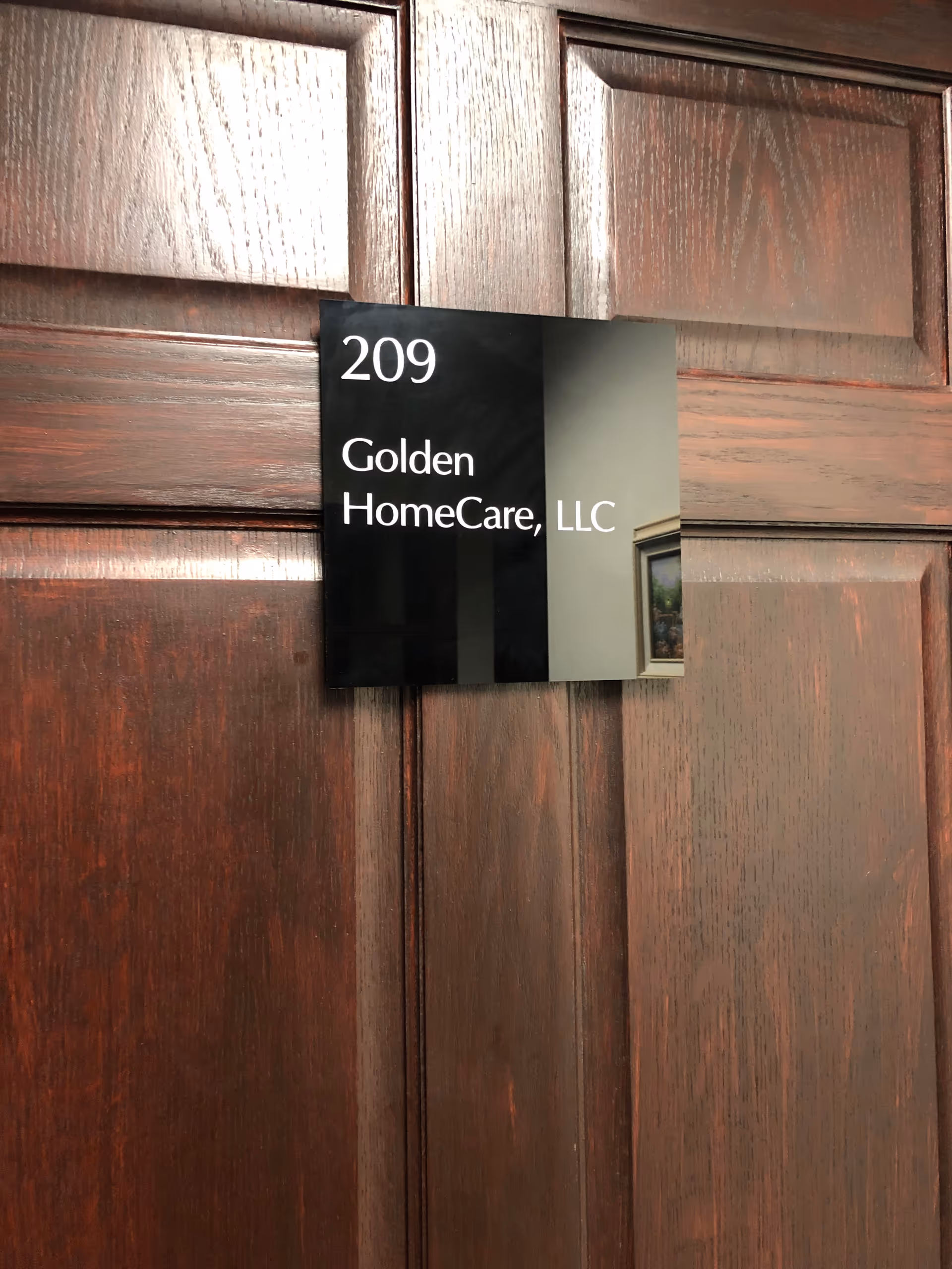 Wooden door with plaque reading 209 and Golden HomeCare, LLC