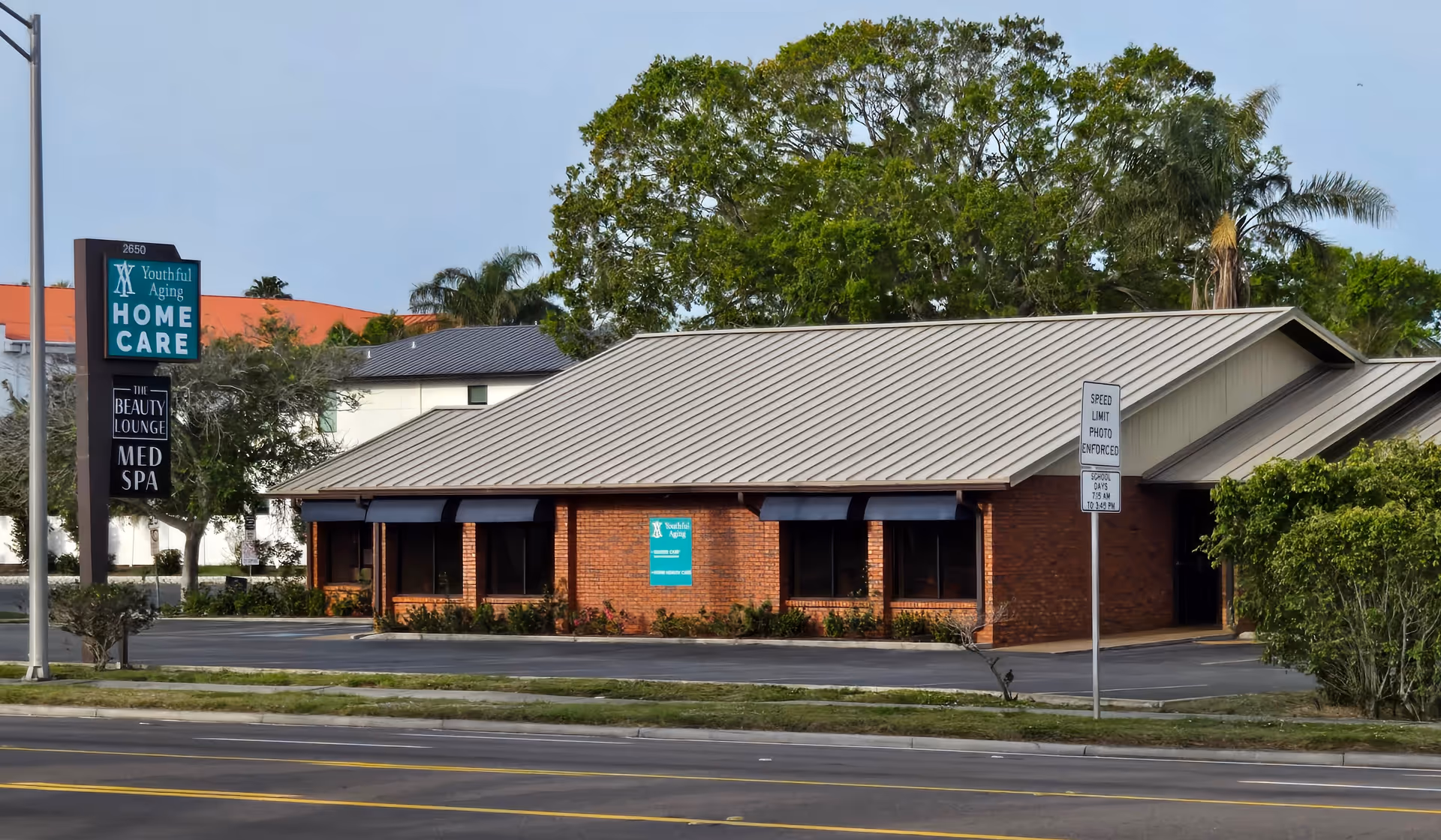 Front view of a single-story brick building labeled Youthful Aging Home Care with parking lot.