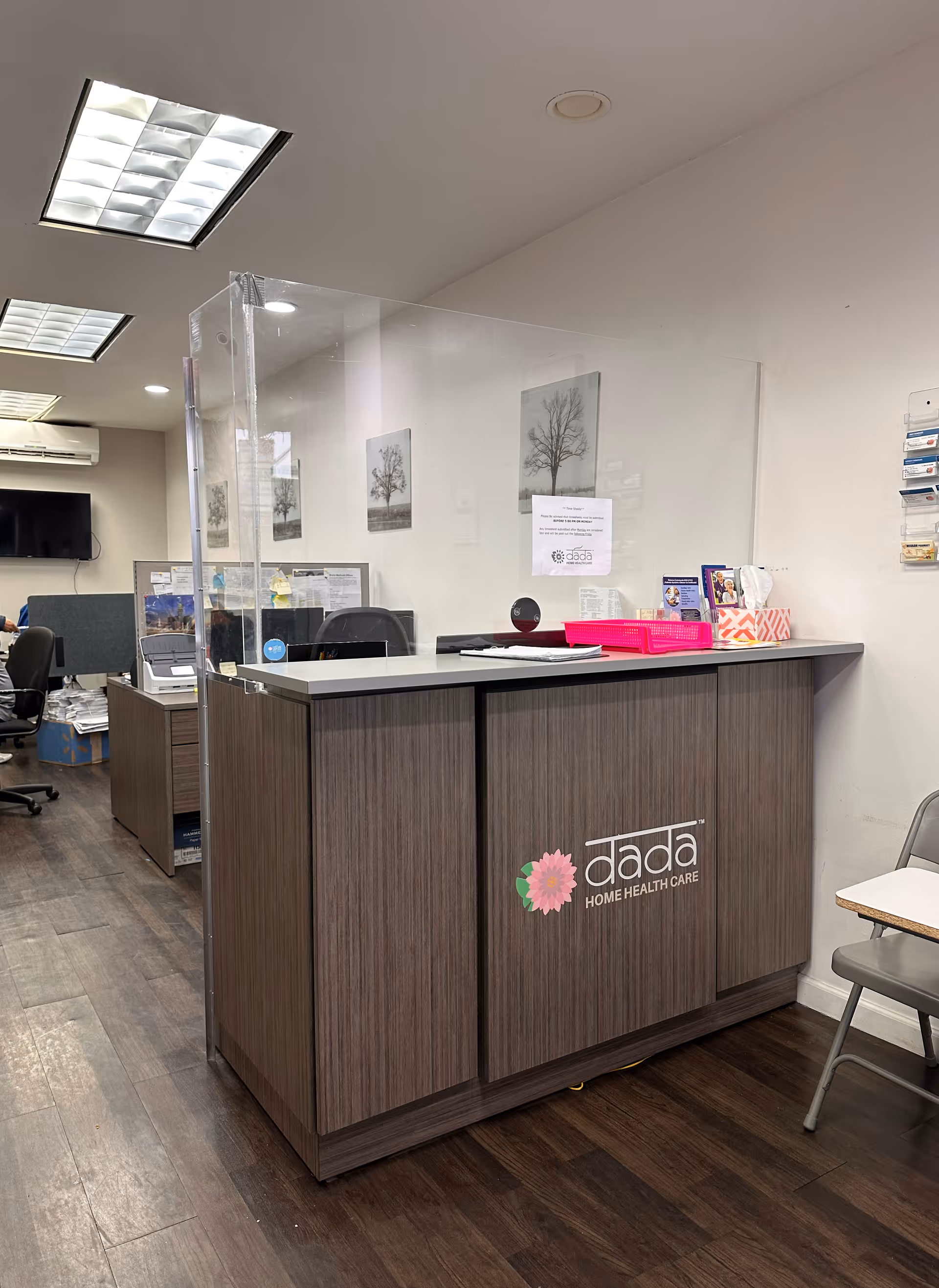 Reception desk with a glass divider in a Dada Home Health Care office interior.