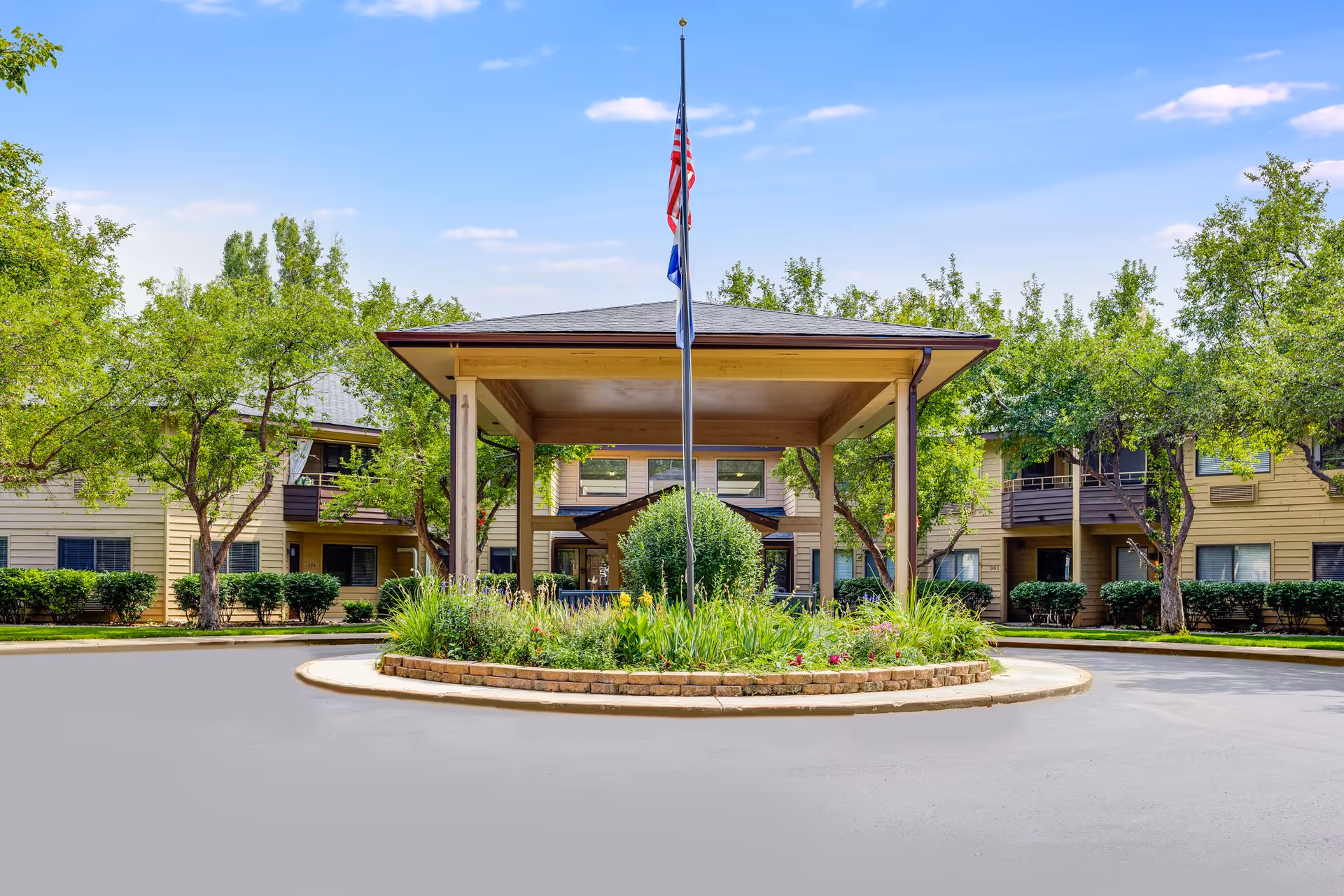 Front view of Parkwood Estates showing a circular driveway, flagpole, and landscaped island.