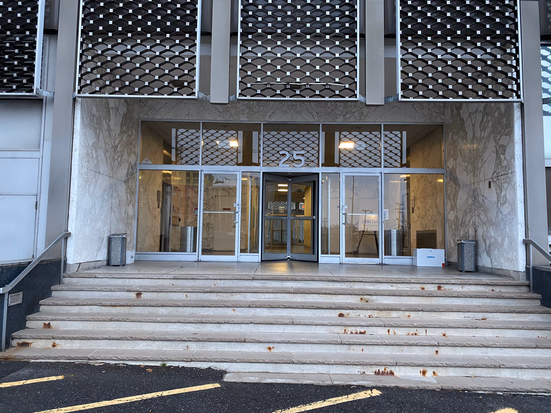 The front entrance of CBH Care facility with glass doors and marble walls.