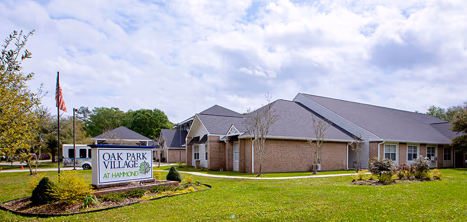 Exterior view of Oak Park Village at Hammond with sign and landscaped lawn.