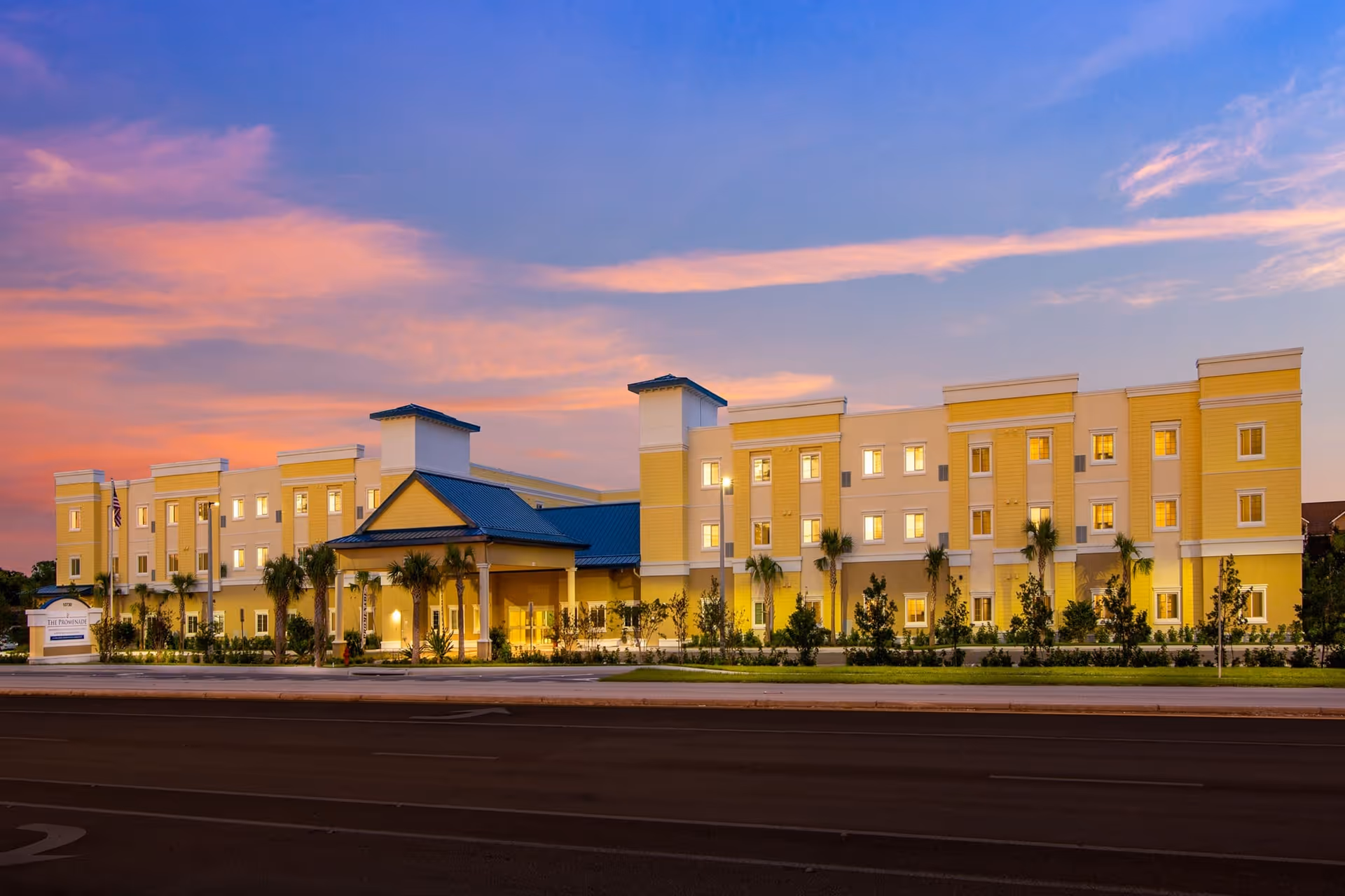 Exterior view of Concordis Senior Living building at sunset with palm trees.
