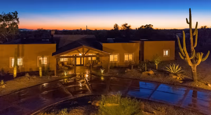 Twilight exterior view of North Scottsdale Retreat with a desert courtyard and pool.