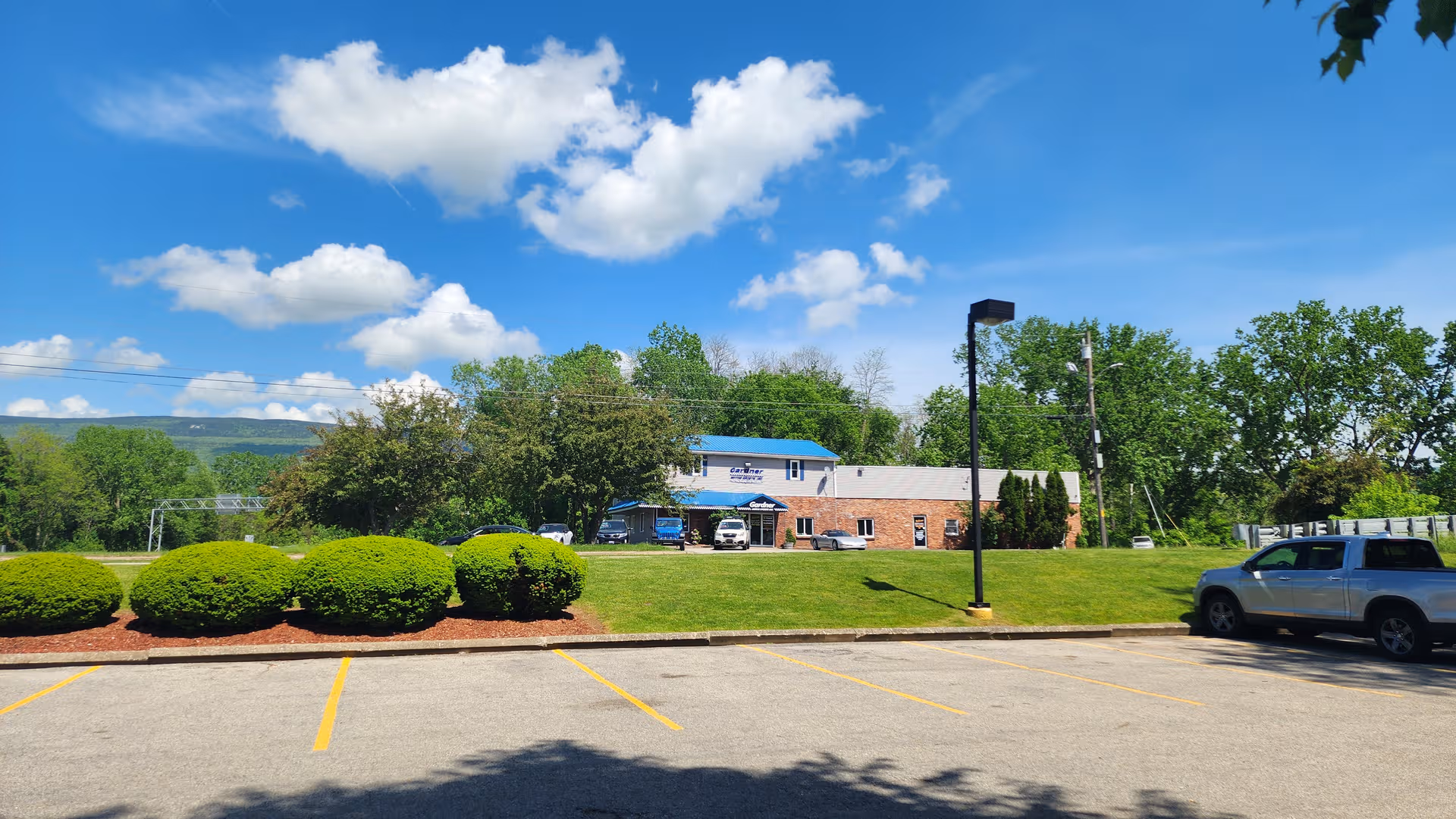Exterior view of Rivers Edge Community Care Home with parked cars and lawn under blue sky