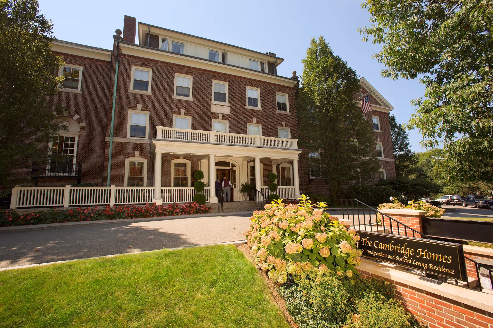 Brick senior living residence with front entrance, columns, and a Cambridge Homes sign.