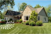 Stone-faced retirement community building with manicured lawn and trees.