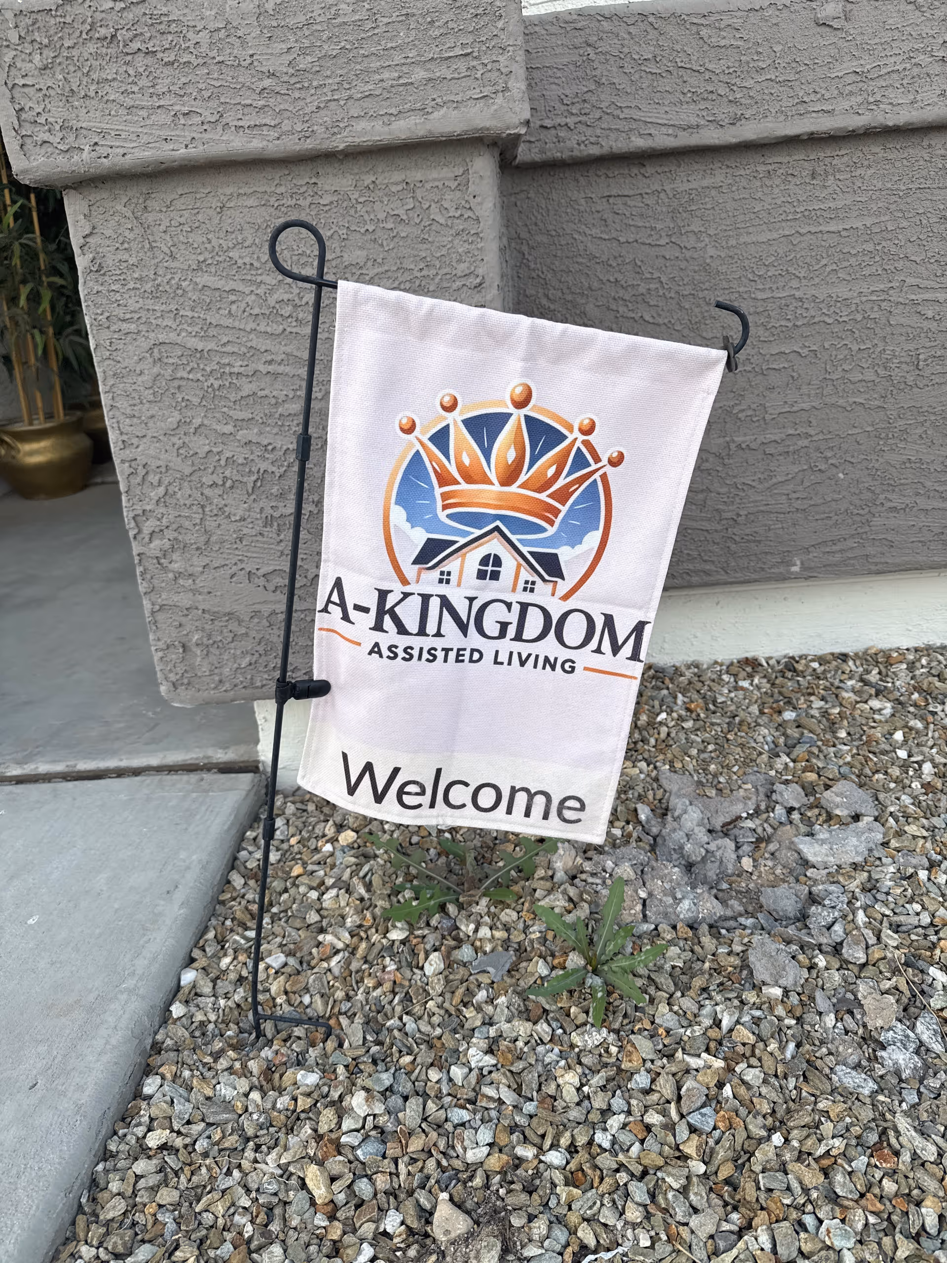 Exterior sign for A-Kingdom Assisted Living by the building entrance.