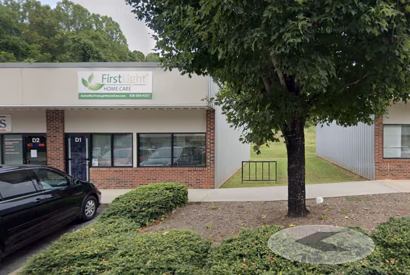 Exterior view of FirstLight Home Care storefront with tree and parked car