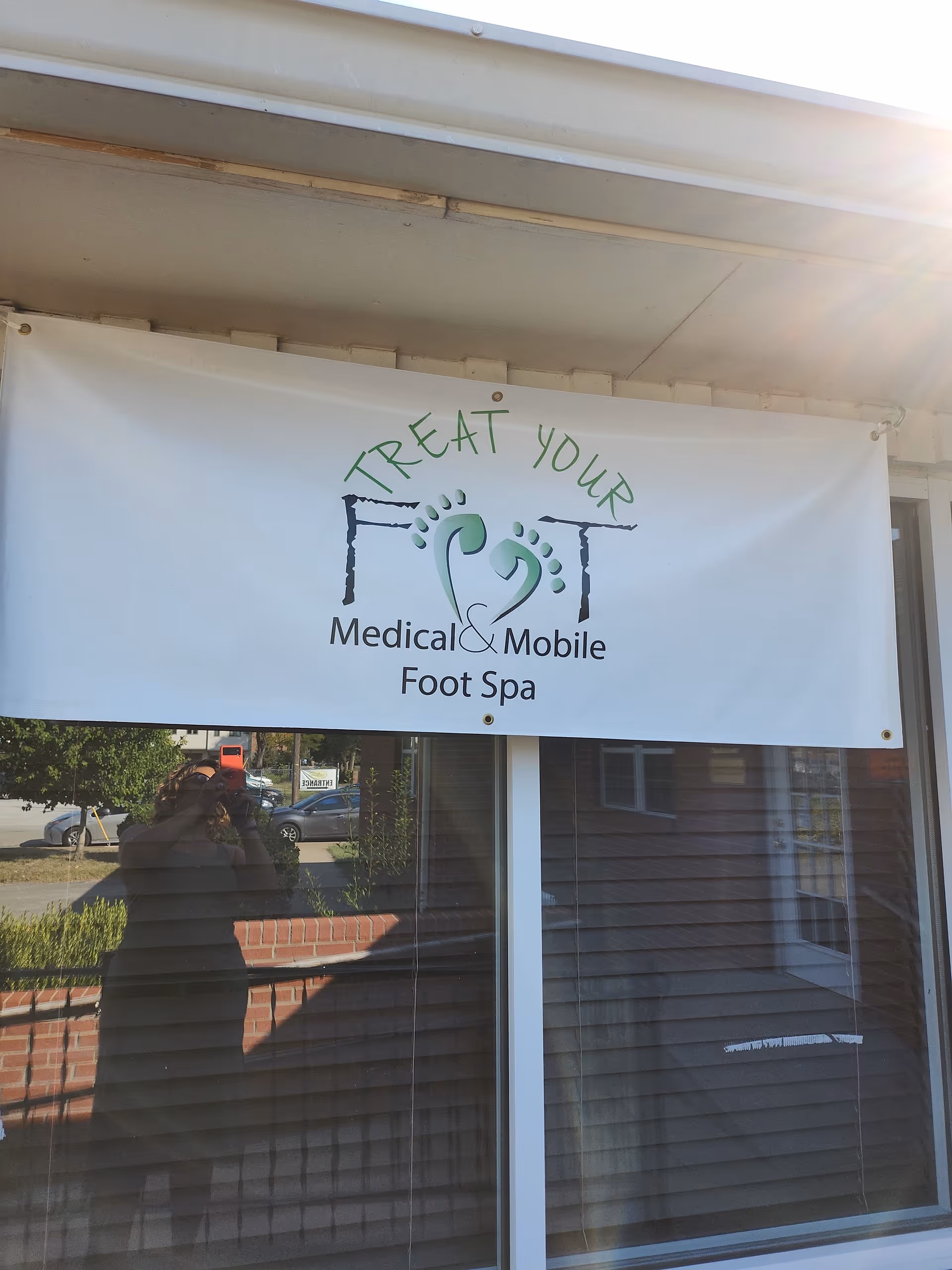 White banner reading Treat Your Foot Medical and Mobile Foot Spa hangs above glass storefront.