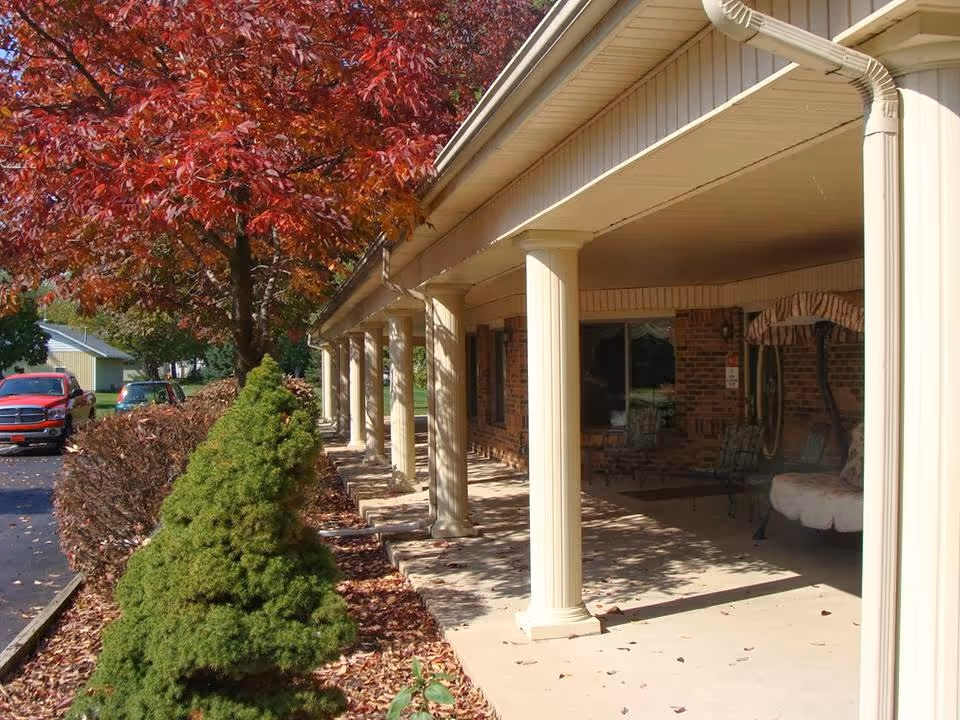 A covered brick-front porch with columns and outdoor seating along the Lakeview Commons building.