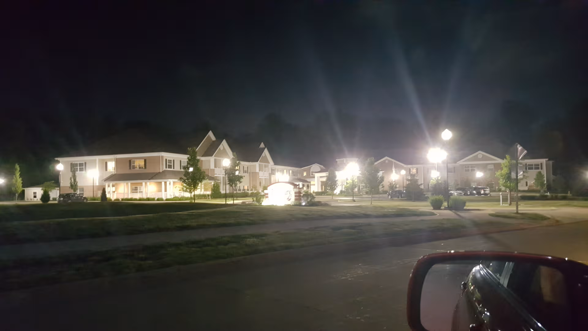 Night view of a multi-wing senior living facility's front exterior with lit entrances