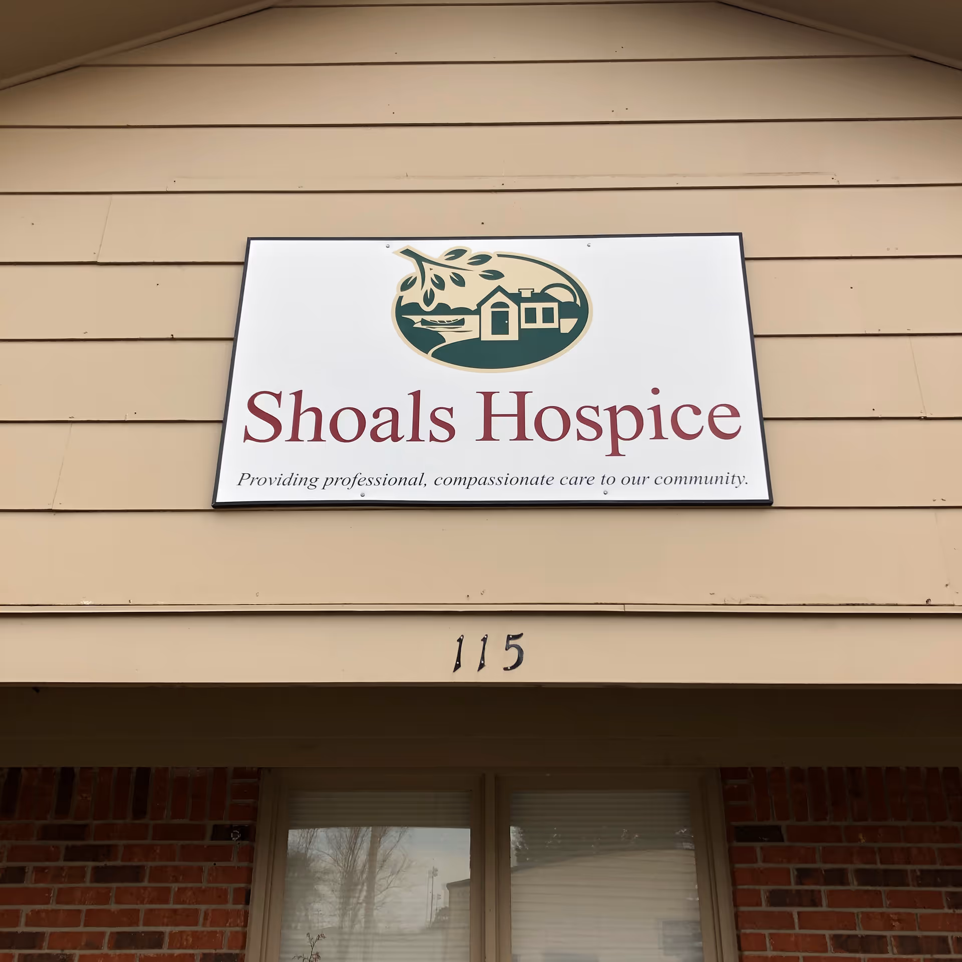 Exterior building front with Shoals Hospice sign and address number 115.