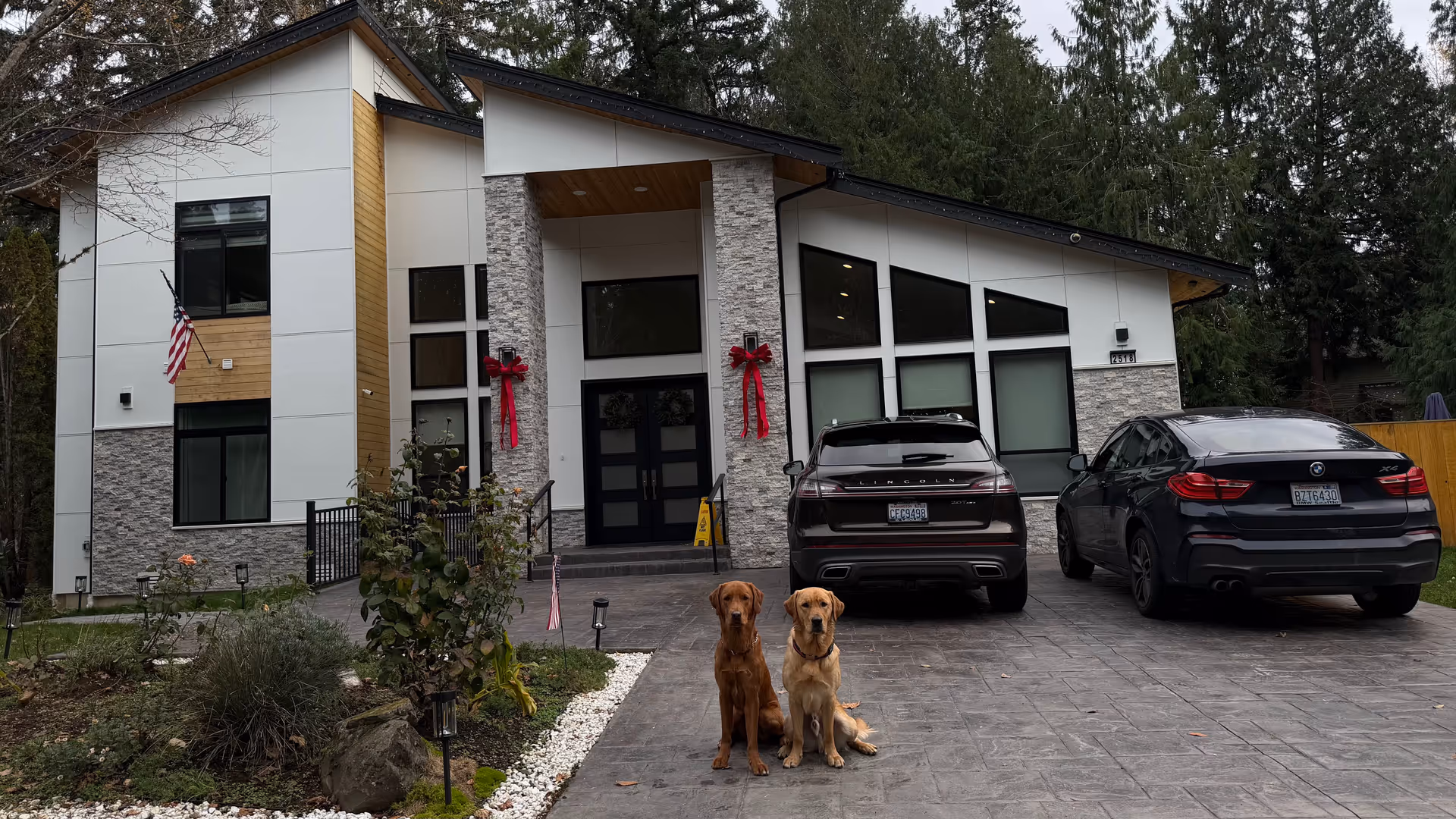 Front view of a modern senior living facility with two dogs near parked cars.