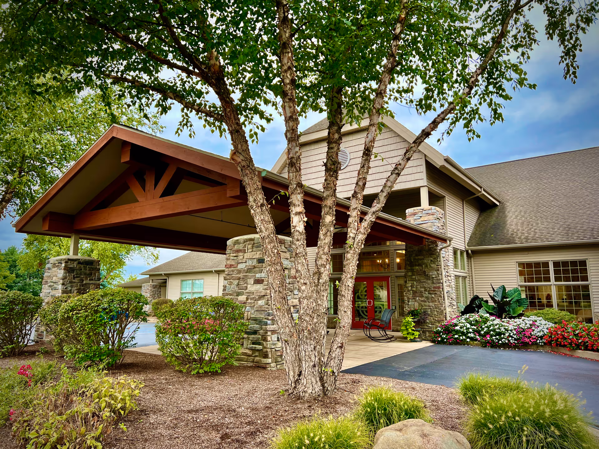 Exterior view of Cambrian Senior Living Tecumseh with a covered entry and landscaped grounds.